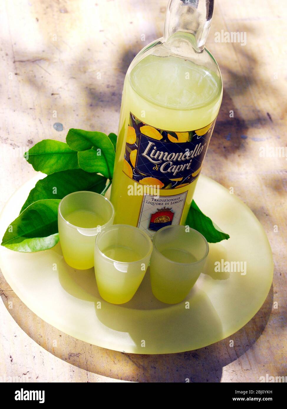 Botella de licor de limoncello con tres vasos - Foto de stock