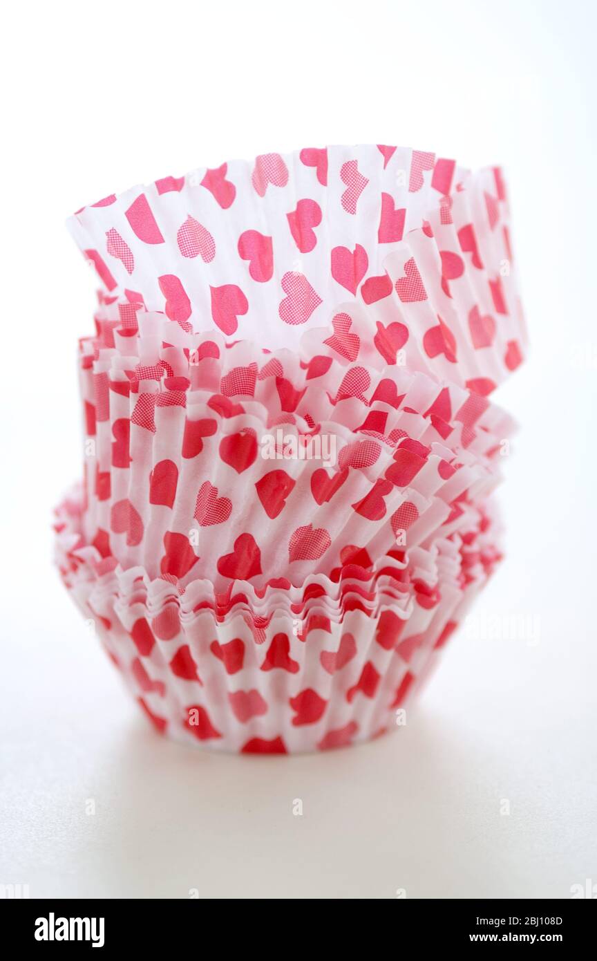 Estuches de papel para hacer muffins y pasteles de hadas - decorados con pequeños corazones rojos - Foto de stock