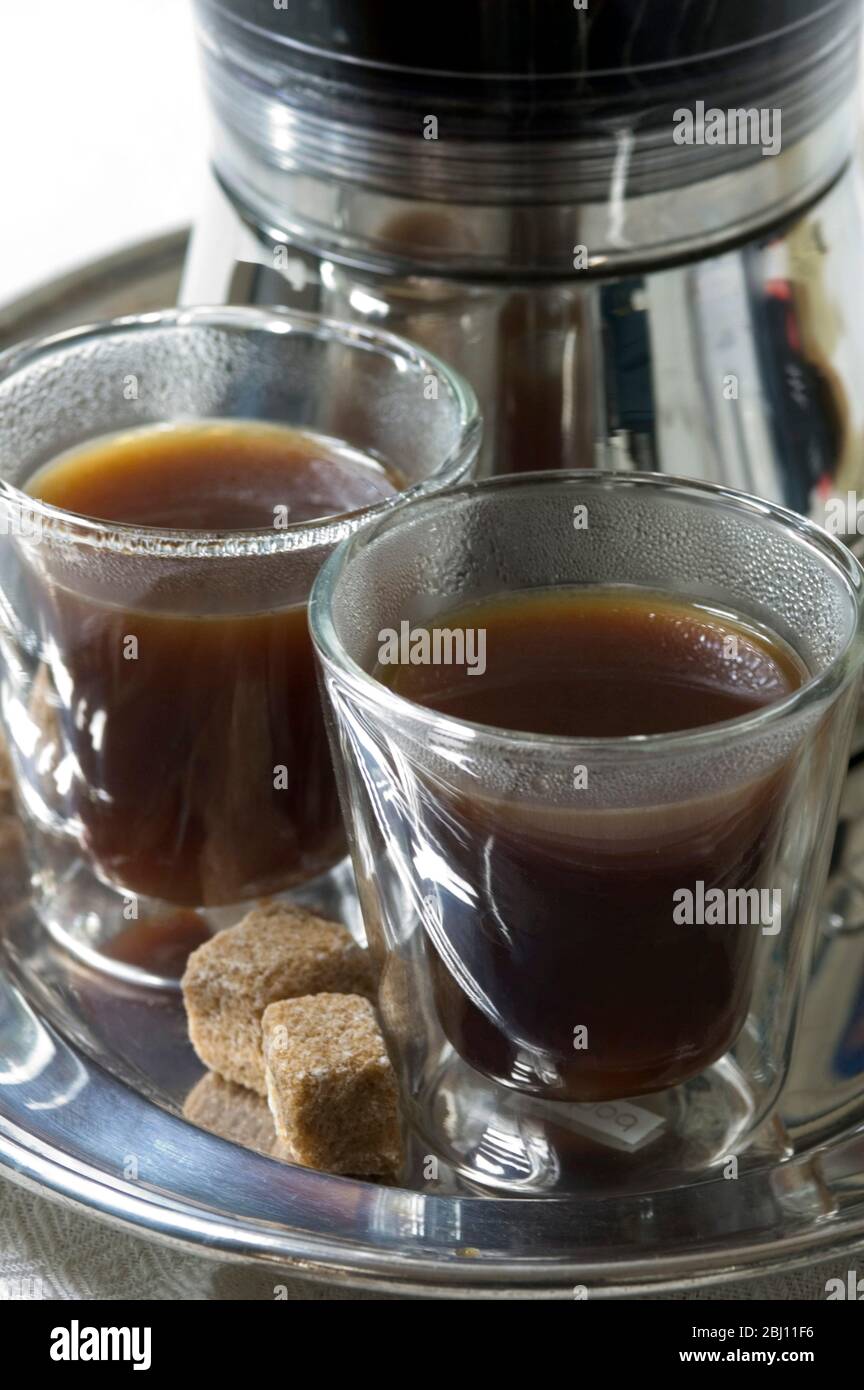 Cafetera espresso eléctrica con vasos de café de cristal aislados con masas  de azúcar natural Fotografía de stock - Alamy