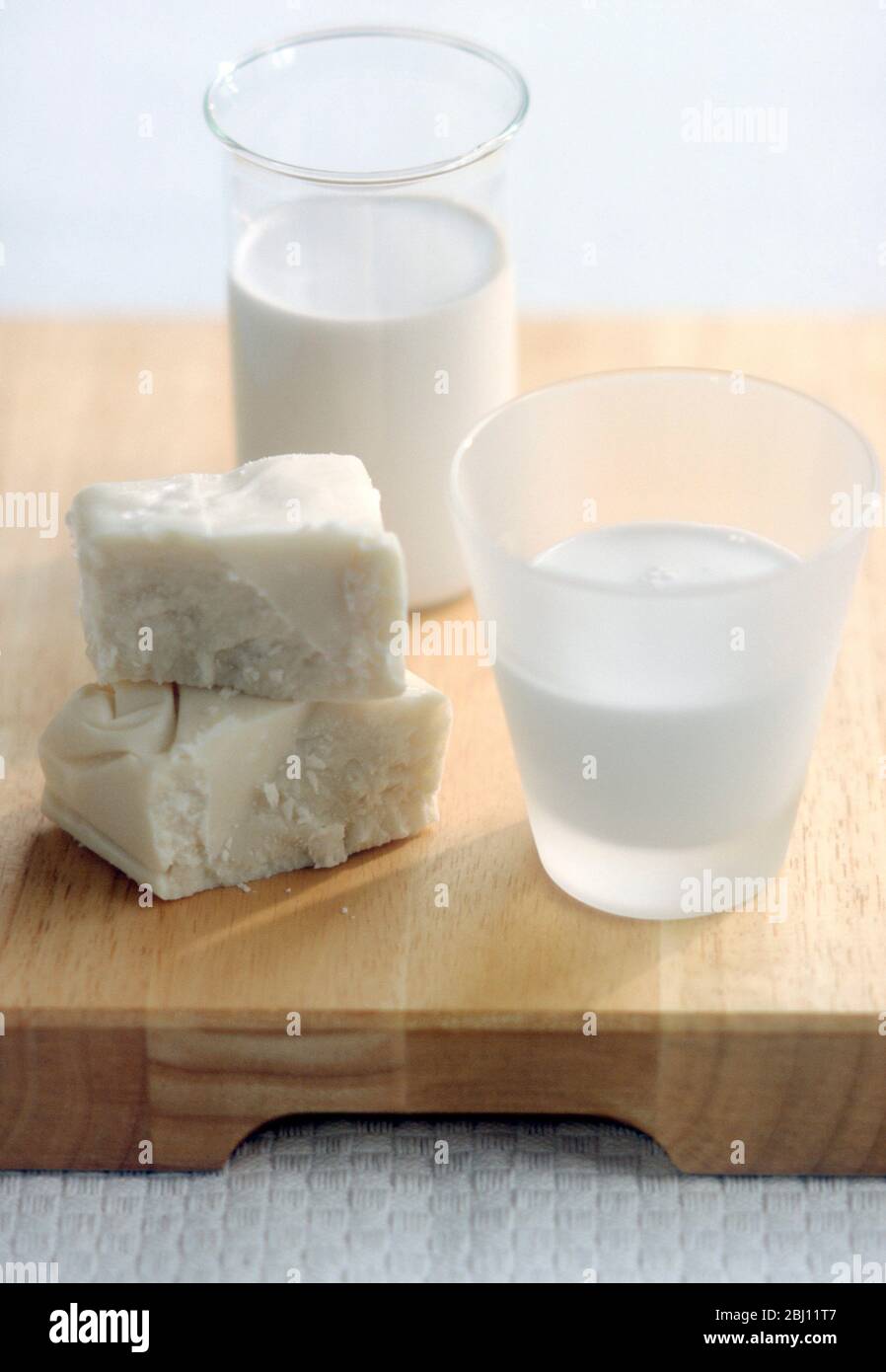 bloque de coco cremado, y vasos de leche de coco y crema - Foto de stock