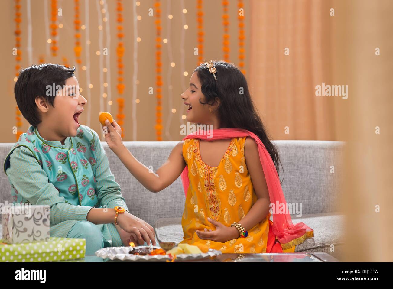 Hermana pequeña dando laddo a su hermano en Rakshabandhan Foto de stock