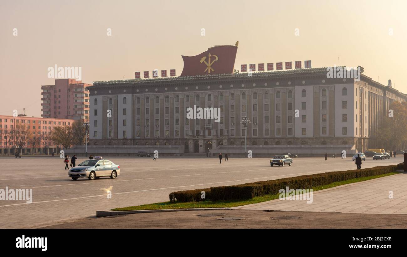 Pyongyang / DPR Corea - 12 de noviembre de 2015: Kim Il-sung Plaza y edificios gubernamentales decorados con banderas y eslóganes revolucionarios en Pyongyang, no Foto de stock