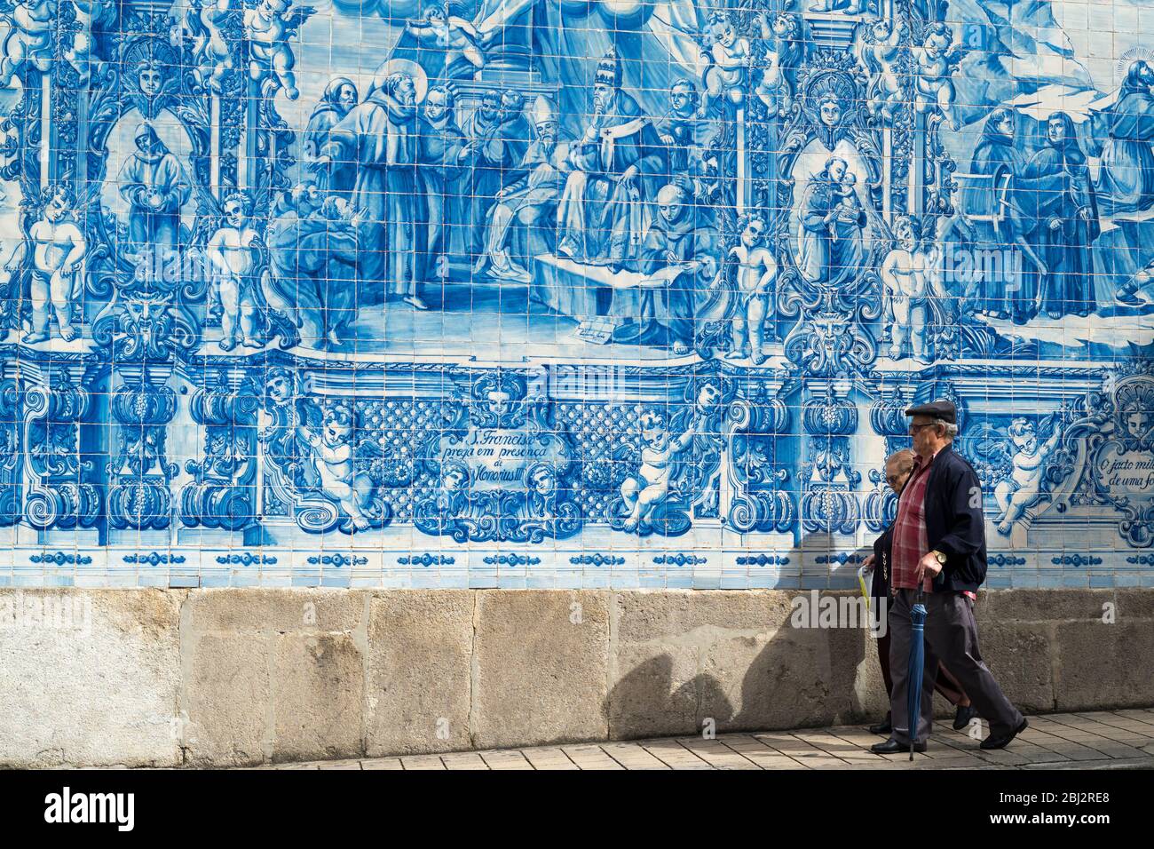 Gente pasando Azulejos portugueses azul y blanco pared de azulejos de Capela das almas de Santa Catarina - Capilla de Santa Catalina en Oporto, Portugal Foto de stock