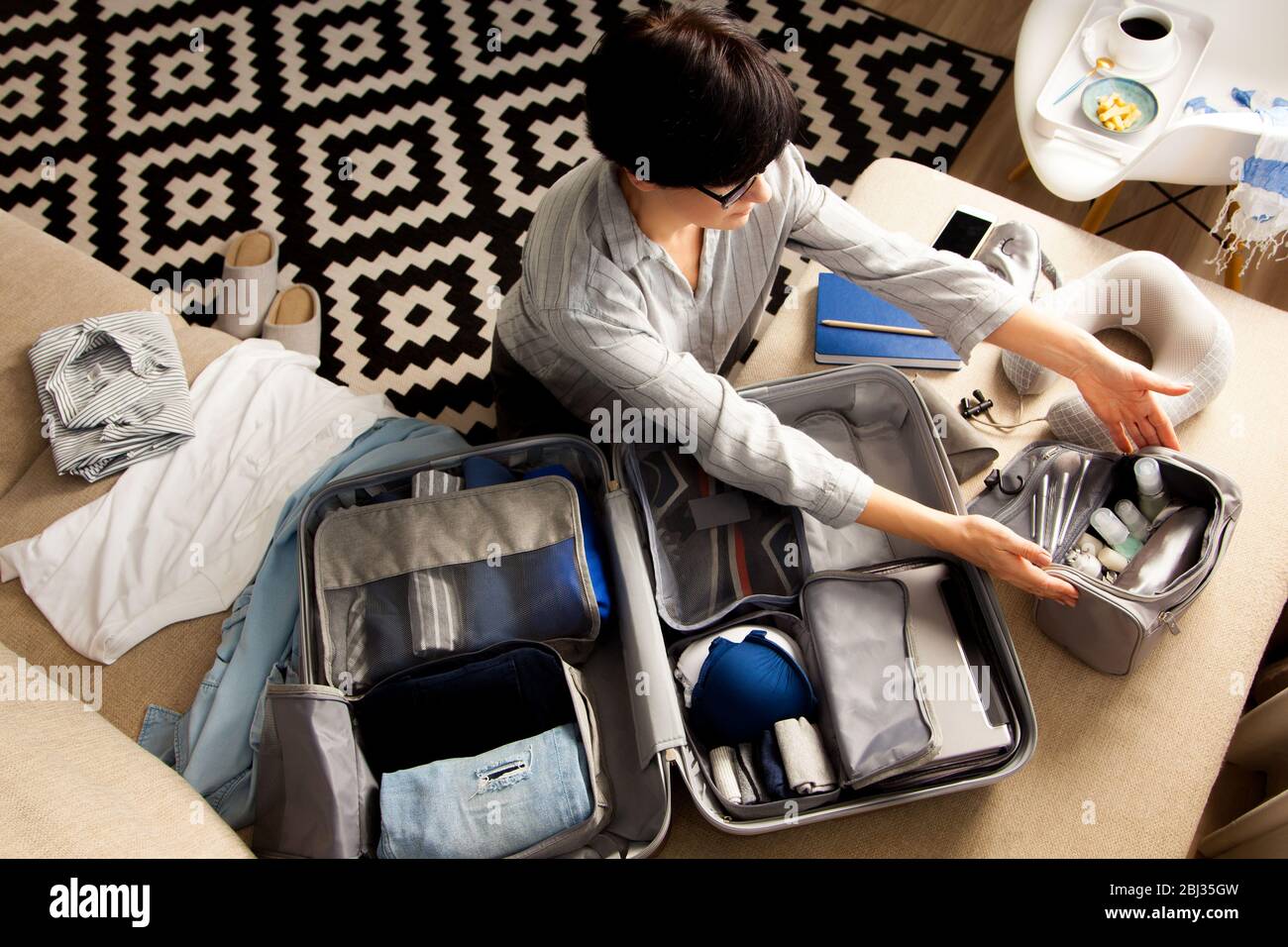 Bolsas de viaje para viajes de vacaciones una mujer joven prepara ropa y  artículos personales para poner en su maleta empaca tus maletas antes de  viajar