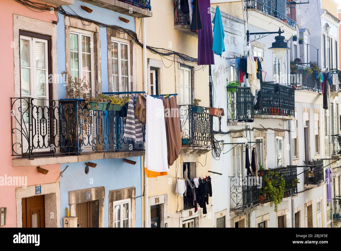 Típico paisaje urbano empinado portugués, lavandería colgada para secar en las líneas de lavado y balcones en Lisboa, Portugal Foto de stock