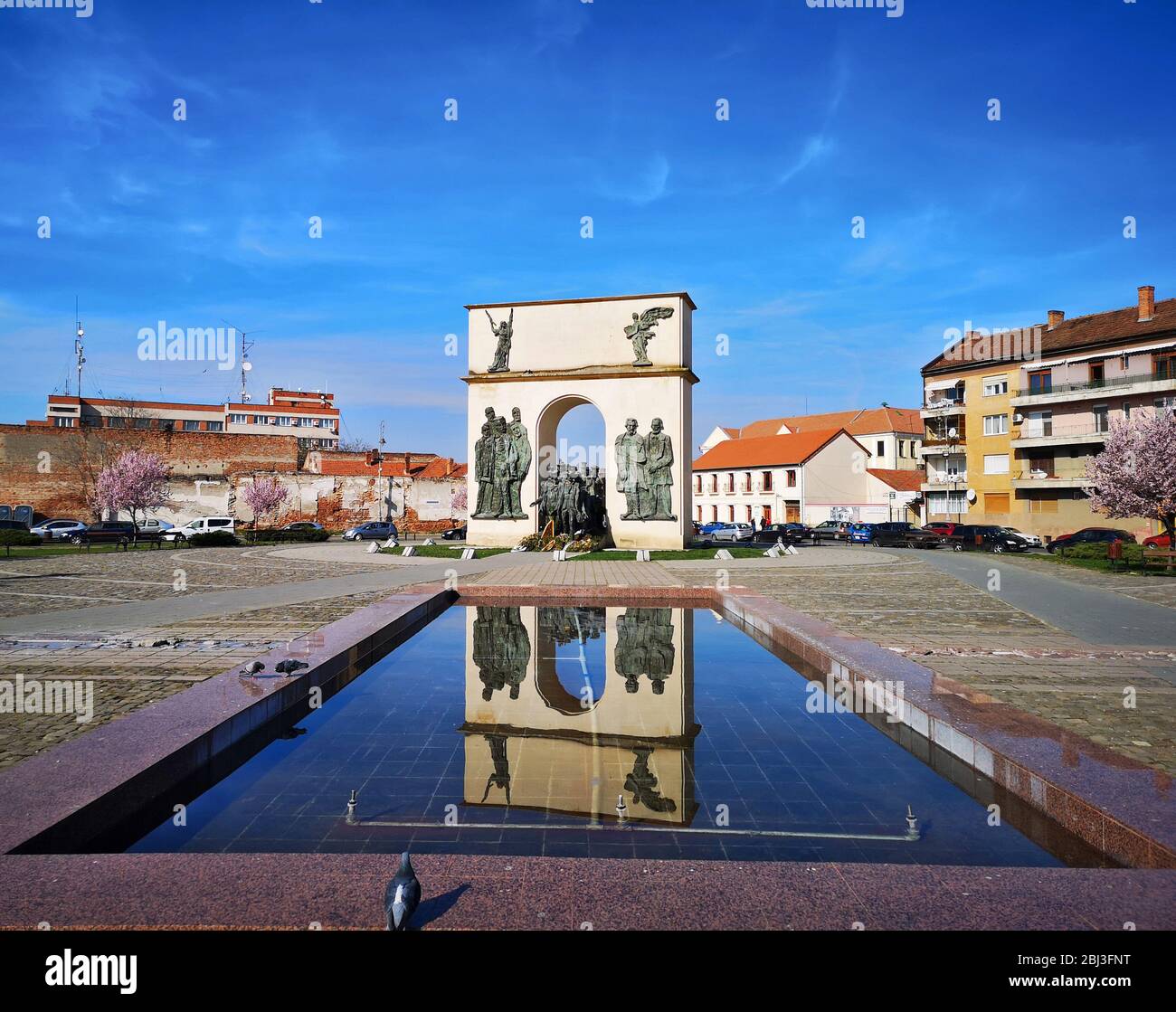 Vista del paisaje con arco monumento reflejado en la fuente de agua en una plaza de la ciudad, restaurante europeo arquietetcural punto de referencia en Arad, Rumania, tomado el 03/ Foto de stock