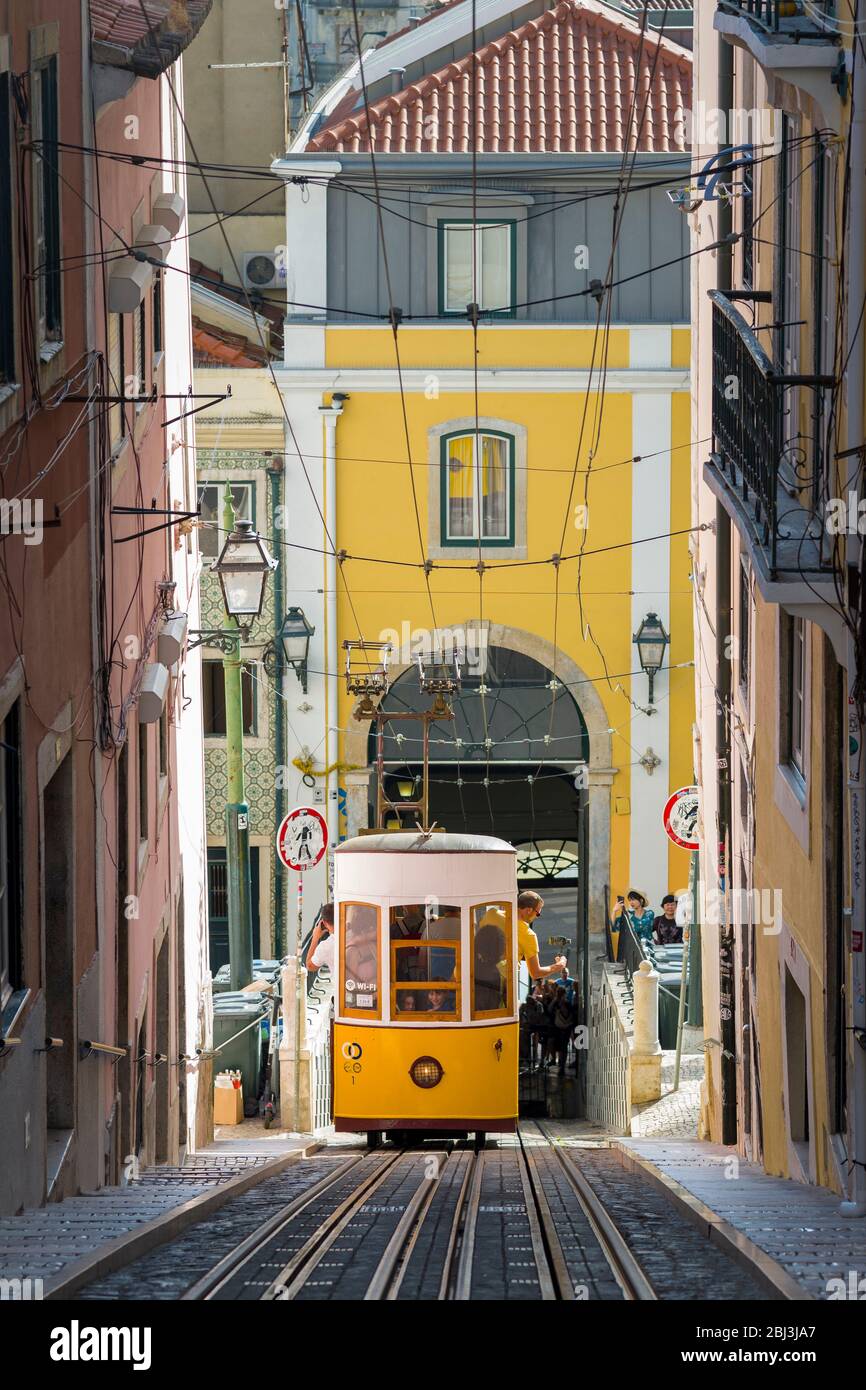 Funicular - elevador da Bica, llevando a la gente local y turistas en las vías de tranvía en una colina empinada en la ciudad de Lisboa, Portugal Foto de stock