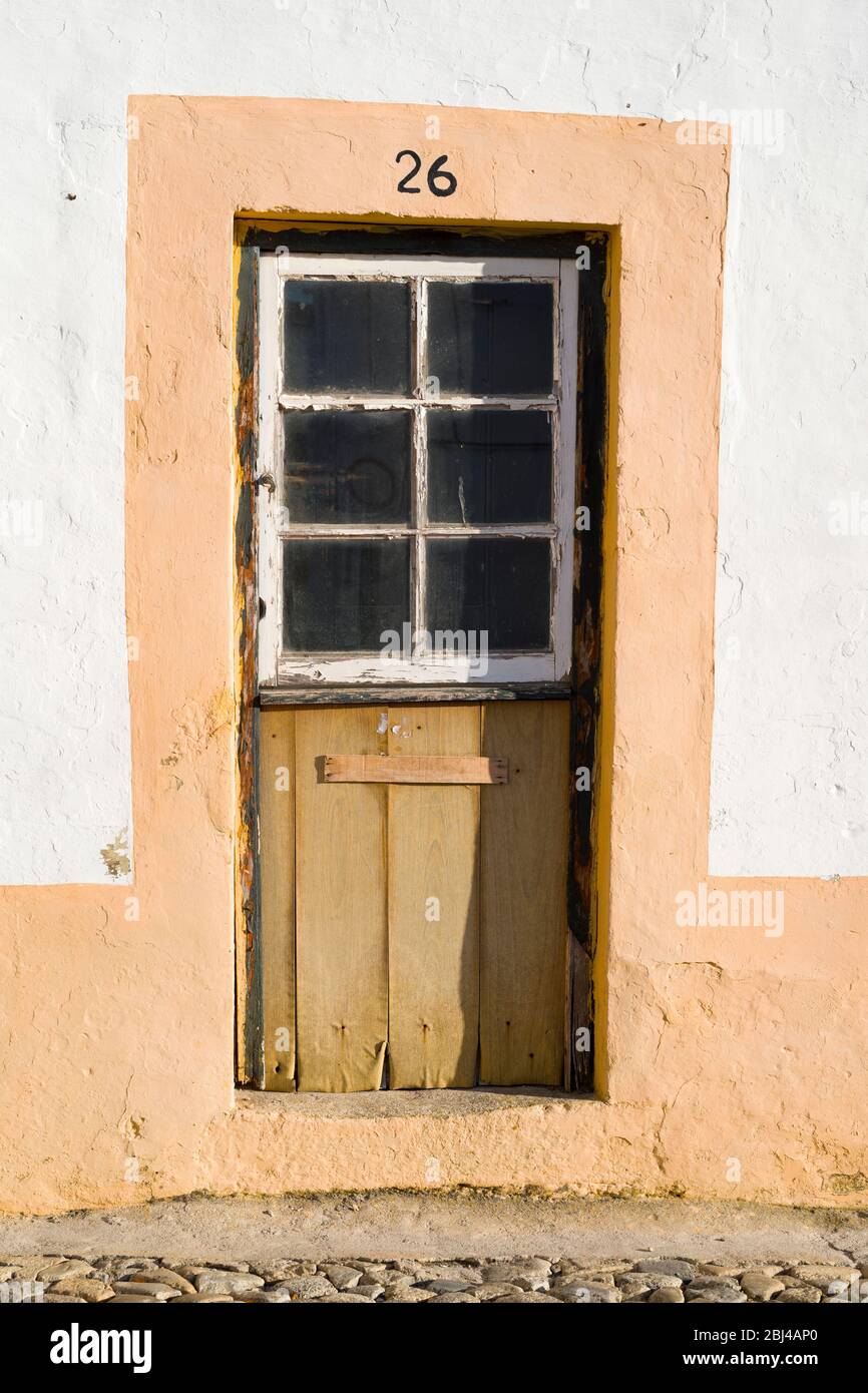 Típica casa pintoresca con puerta antigua en la calle de piedra adoquinada en Évora, Portugal Foto de stock