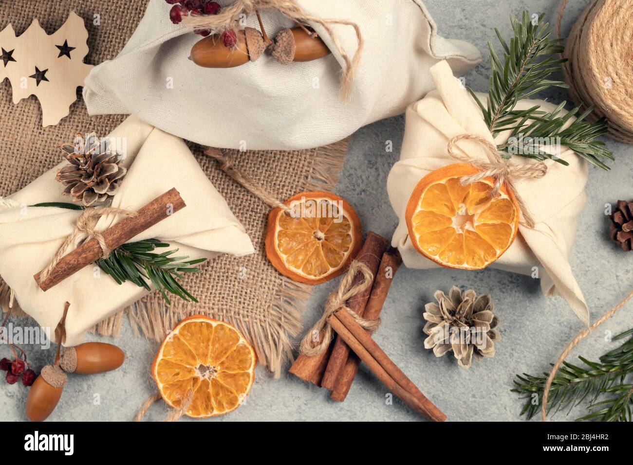 Concepto de Navidad sin residuos. Con regalos y adornos de tejido natural de materiales naturales en una mesa gris, vista superior, Foto de stock