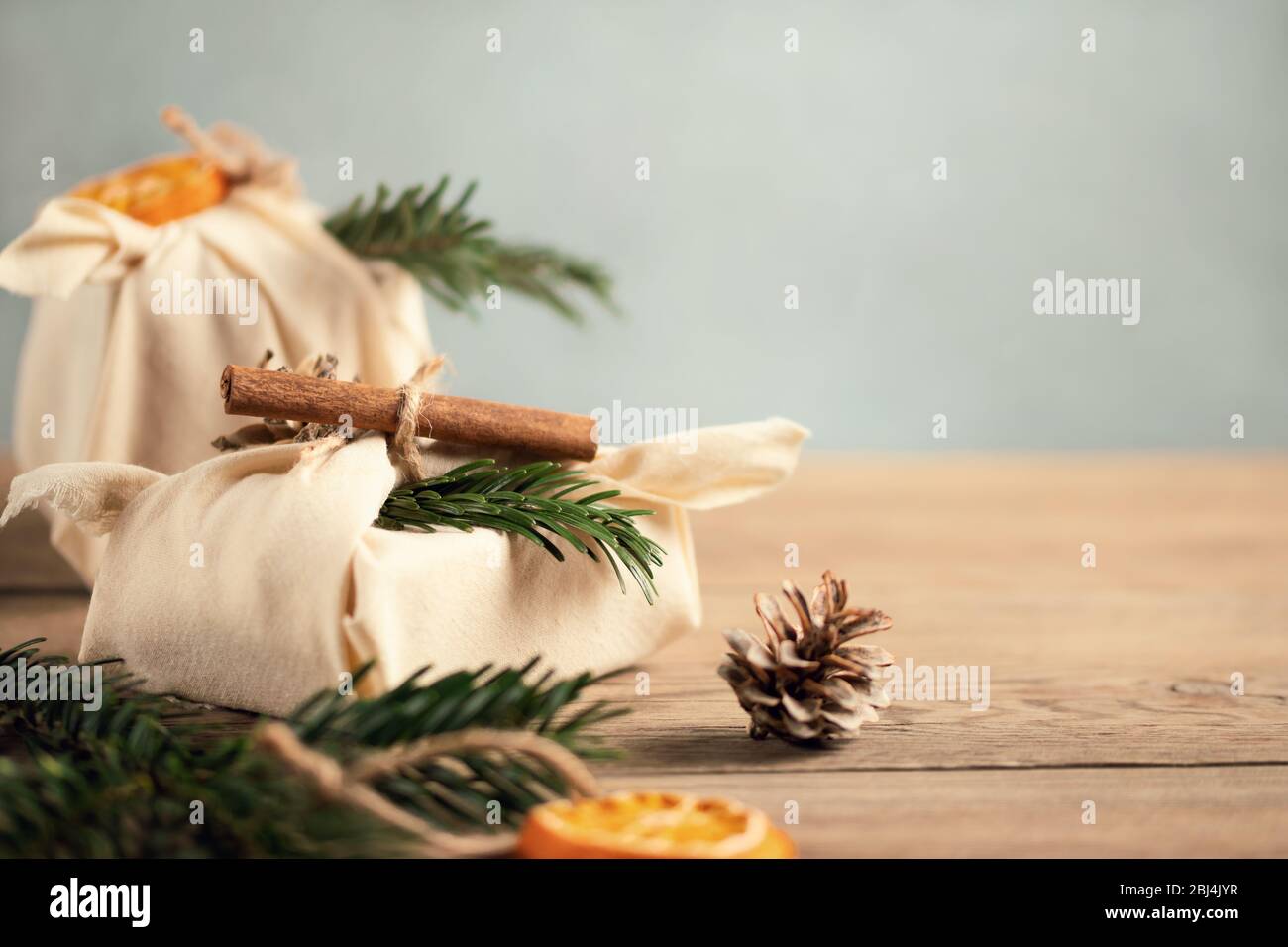 Concepto de Navidad sin residuos. Con regalos y decoraciones de tela natural de materiales naturales en una mesa gris, espacio para copias. Foto de stock