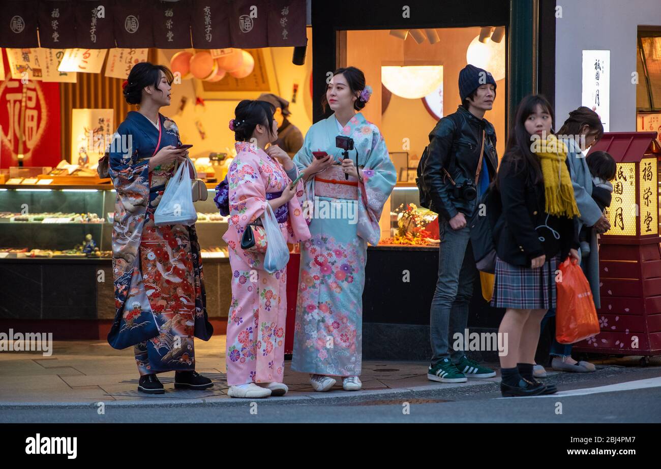 Un grupo de mujeres japonesas vestidas con kimono tradicional en una conversación en la calle principal Shijo-dori de Gion, en Kyoto, Japón Foto de stock