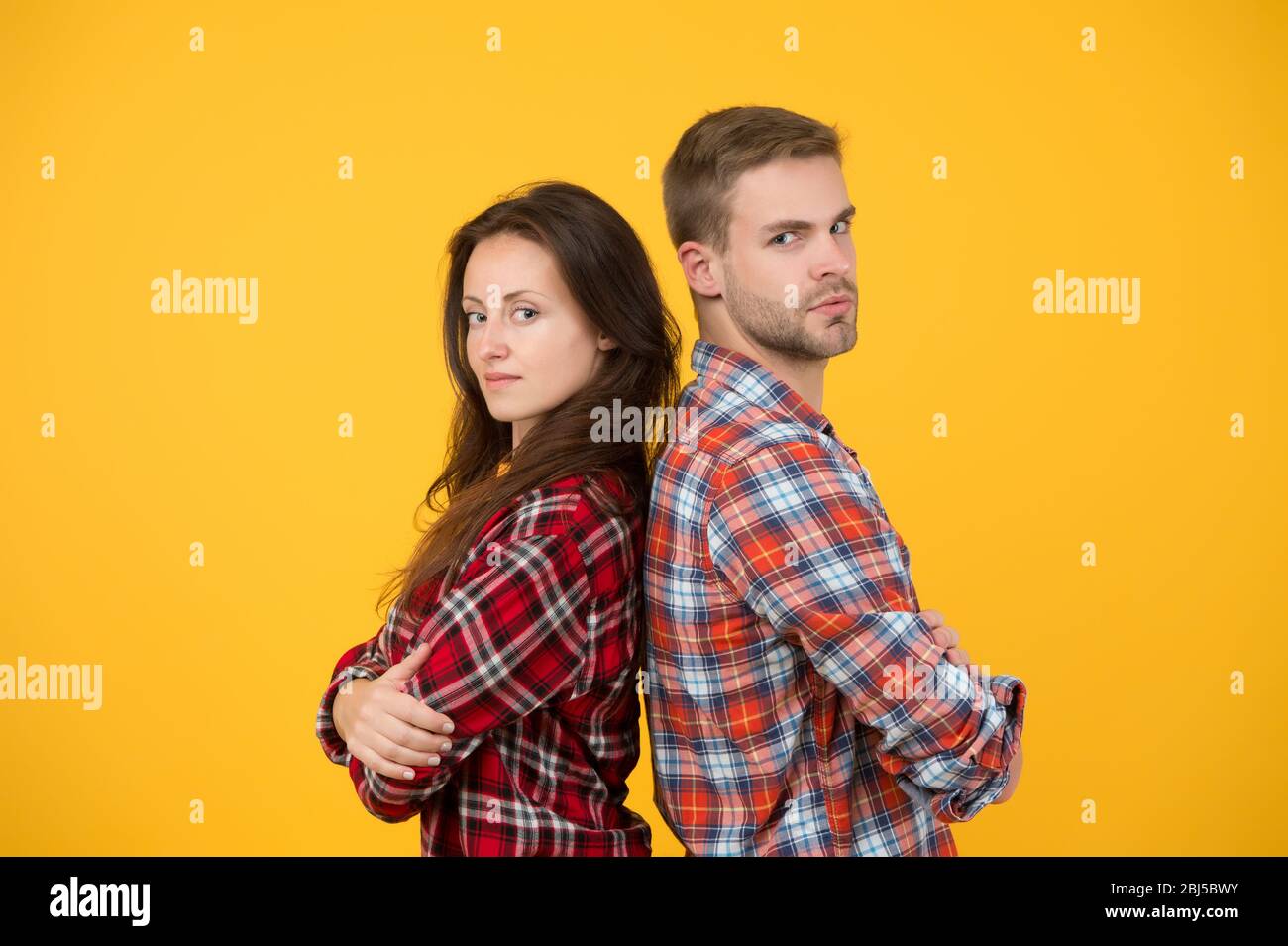 Hermanos adultos. Hermana y hermano. Equipo seguro. De vuelta a atrás  hombre y mujer de pie. Tienda de ropa de moda. Pareja moderna. Camisetas de  cuadros para parejas. Look familiar. Concepto de