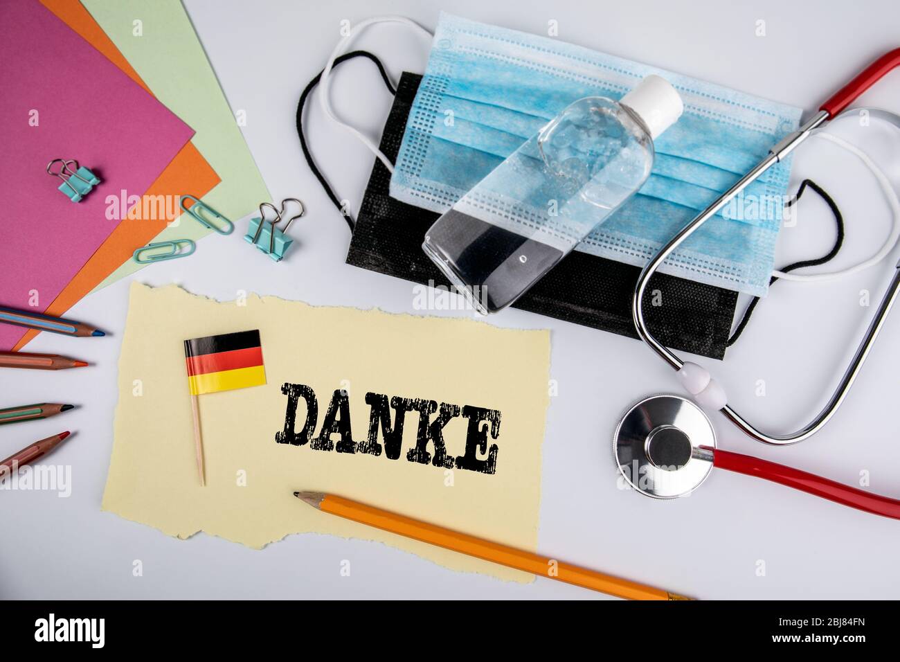 Palabra alemana Danke que significa Gracias. Máscara médica negra y azul,  desinfectante de manos y estetoscopio sobre fondo blanco Fotografía de  stock - Alamy