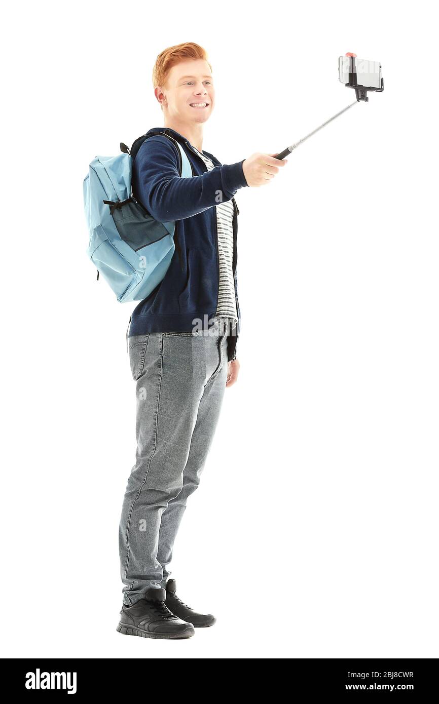 Joven guapo chico con mochila utilizando el palo para la foto por su  propio, aislado en blanco Fotografía de stock - Alamy