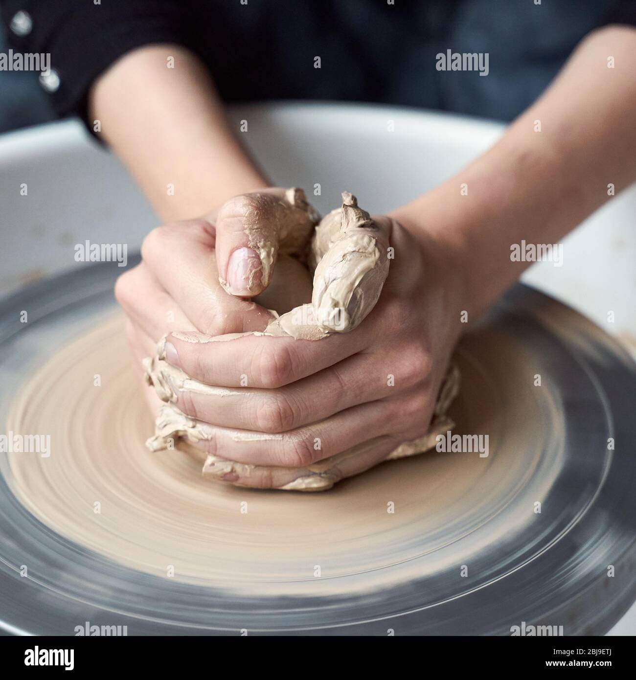 Mujer haciendo cerámica sobre la rueda, manos de cerca, creación de