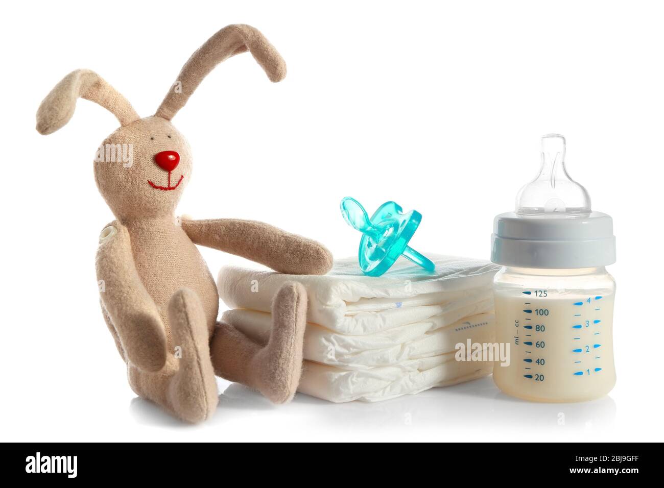 Biberón con leche, pila de pañales y juguete de conejo aislado sobre blanco  Fotografía de stock - Alamy