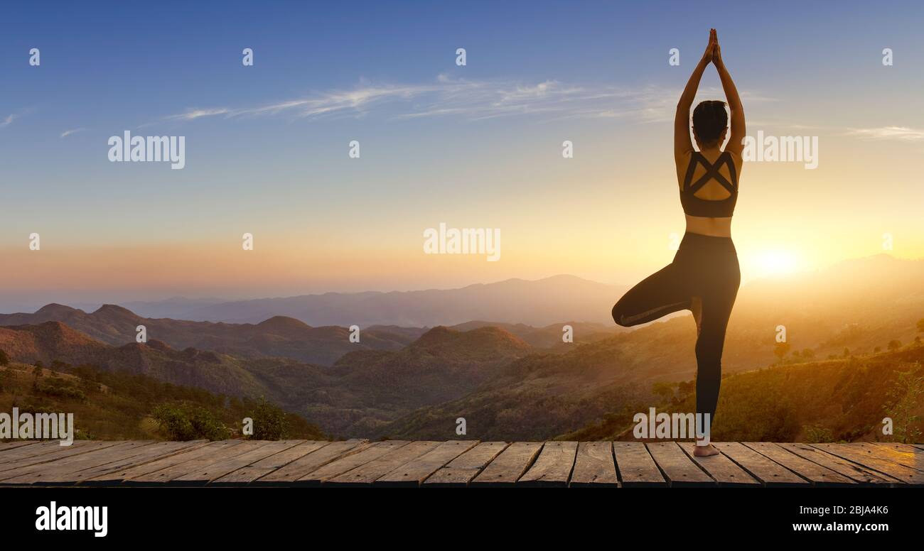 Mujer joven practicando yoga en la felicidad de la naturaleza.mujer. Pose equilibrio cuerpo vital zen y meditación para entrenar naturaleza montaña fondo en morni Foto de stock