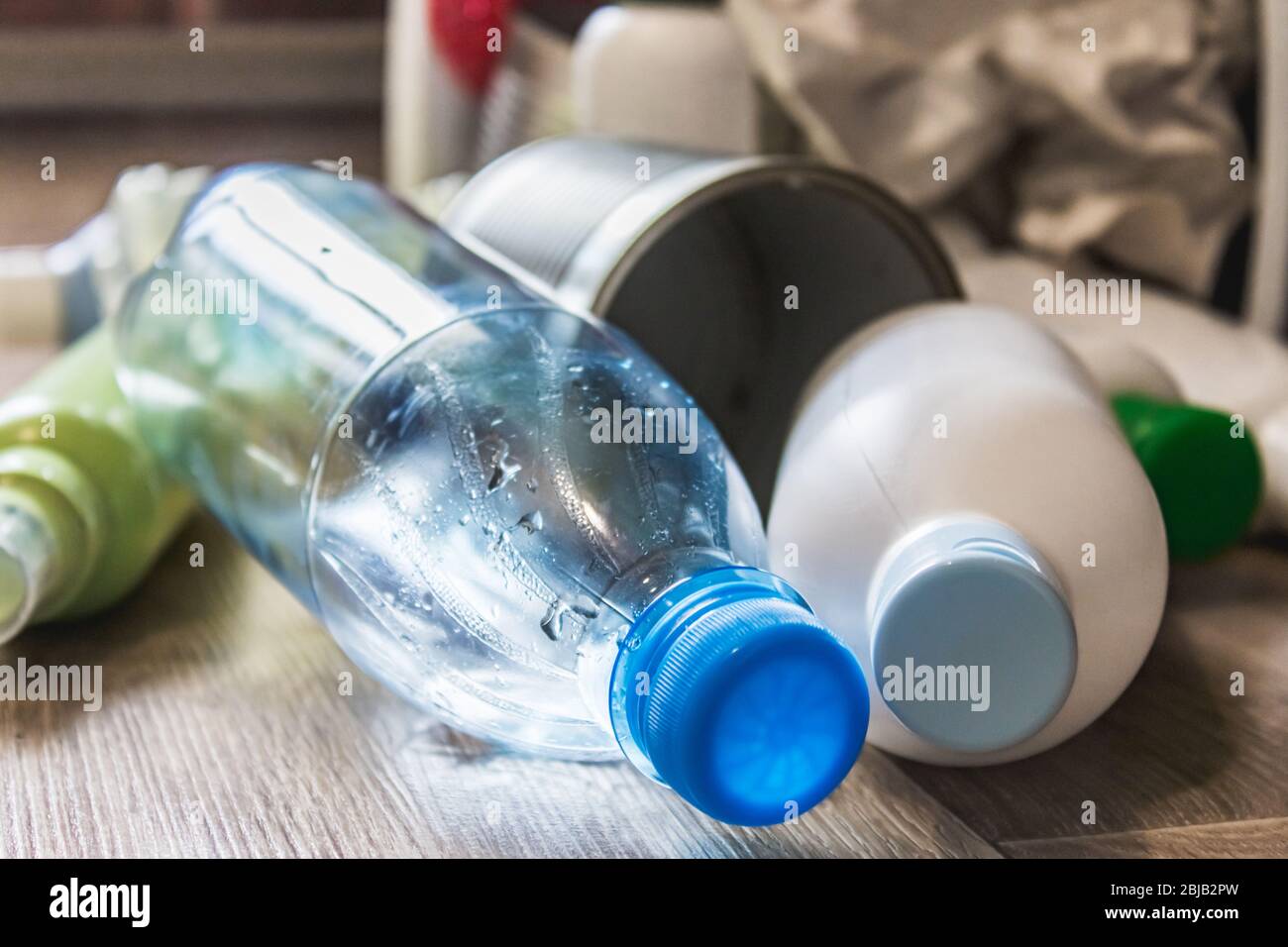 Botellas de plástico, papel y latas de metal están esparcidas por el piso  de la cocina. Basura Fotografía de stock - Alamy
