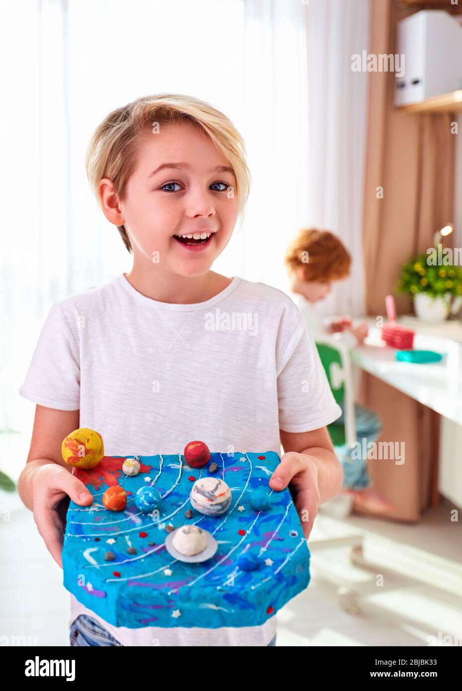 feliz niño de escuela joven, niño mostrando el modelo de sistema solar hecho  de plastilina, cuarto de niños fondo Fotografía de stock - Alamy