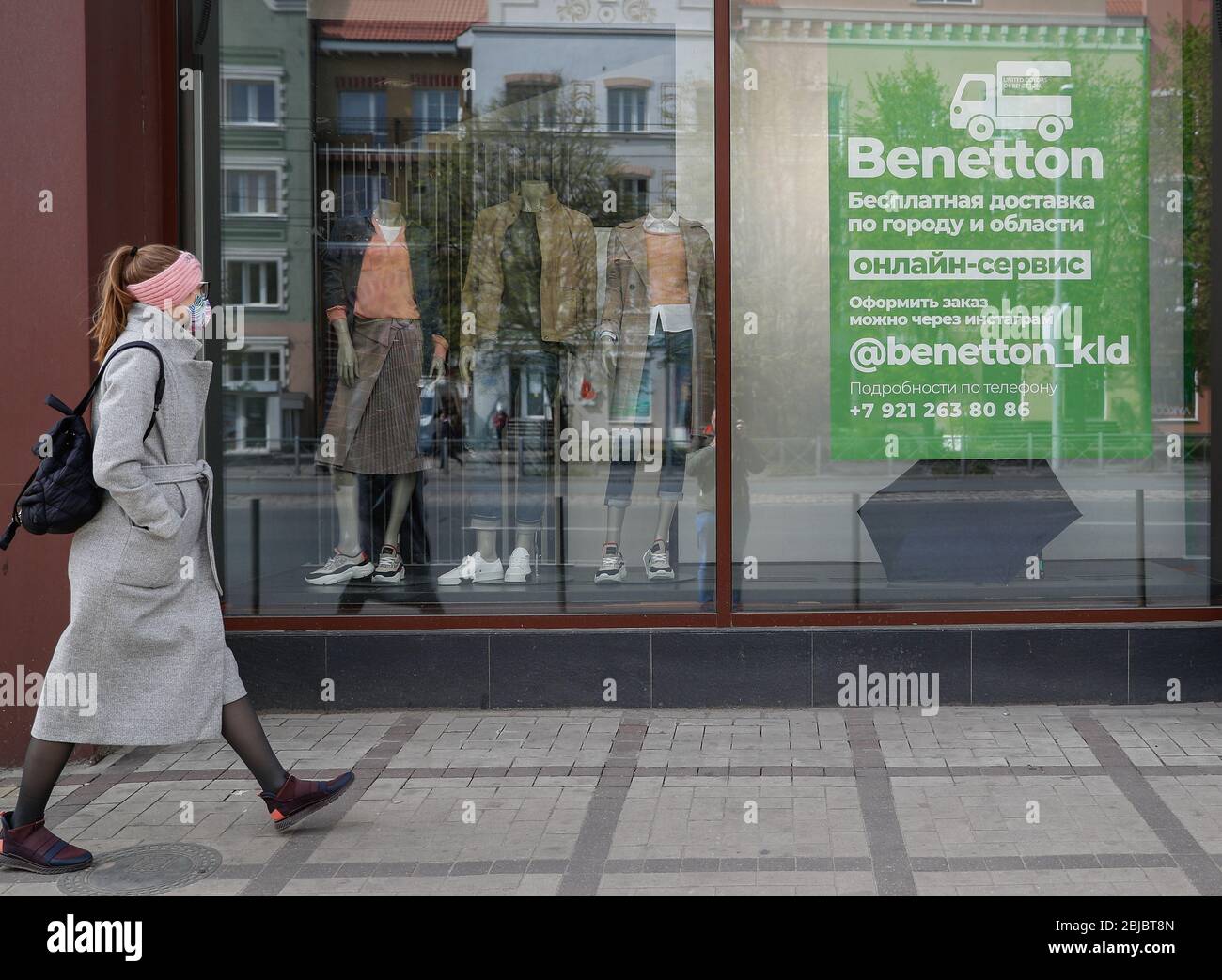 Kaliningrado, Rusia. 29 de abril de 2020. Una niña camina por una ventana  de una tienda de ropa United Colors of Benetton reabierta. Las autoridades  de la región de Kaliningrado han ampliado