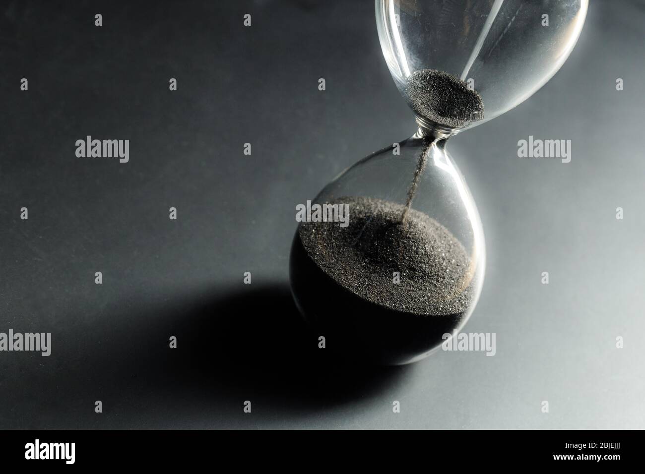 Reloj de arena sobre fondo oscuro. Foto macro. Primer plano. Foto de stock