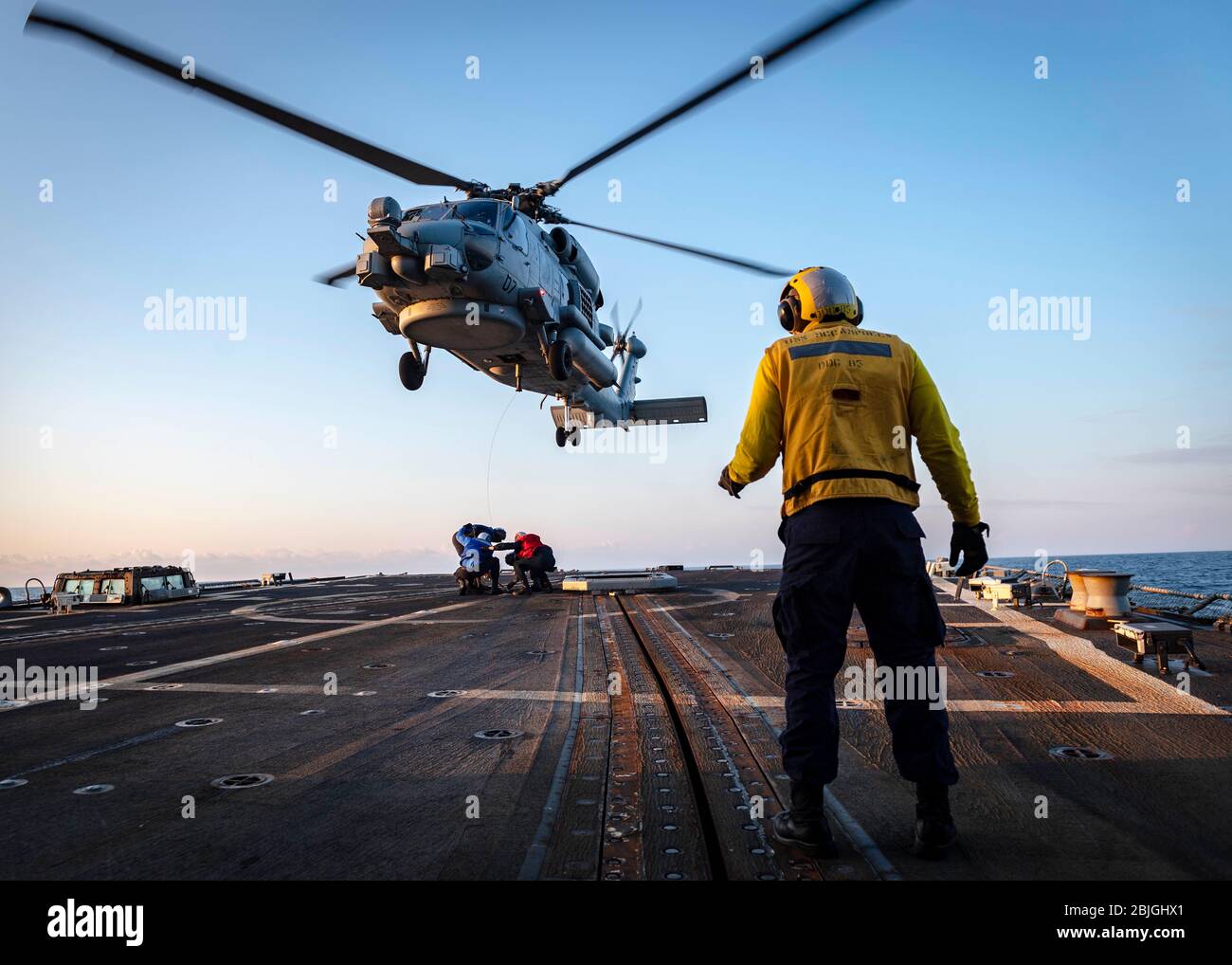 200427-N-WI365-2055 MAR DE JAPÓN (ABRIL 27, 2020) – los marineros estadounidenses simulan una asistencia de recuperación con un helicóptero MH-60 sea Hawk, asignado a los “señores de la guerra” del escuadrón de la huelga Marítima del helicóptero (HSM) 51, en la cubierta de vuelo a bordo del destructor de misiles guiados USS McCampbell (DDG 85) de la clase Arleigh Burke. McCampbell está realizando operaciones en la región del Indo-Pacífico mientras que está asignado al Escuadrón Destroyer (DESRON) 15, el mayor DESRON desplegado hacia adelante de la Marina y la principal fuerza de superficie de la 7a flota de los Estados Unidos. (EE.UU Foto de la Marina por Especialista en Comunicación de masas de segunda clase Markus Castañeda) Foto de stock