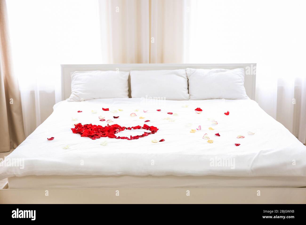 Pétalos de rosa en la cama de la habitación del hotel Fotografía de stock -  Alamy