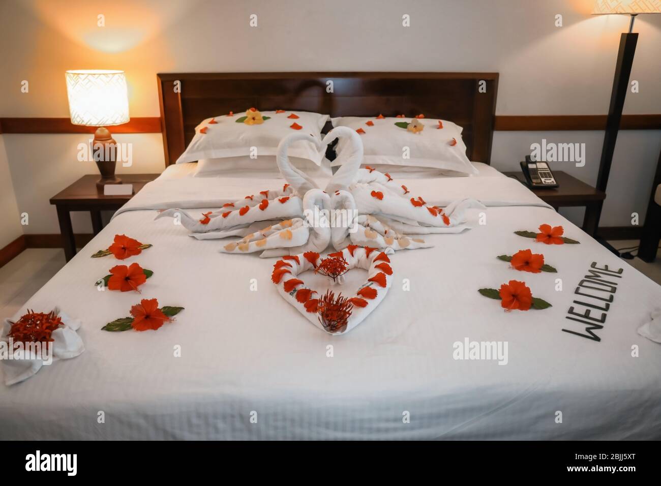 Cama decorada con flores y toallas en la habitación del hotel Fotografía de  stock - Alamy