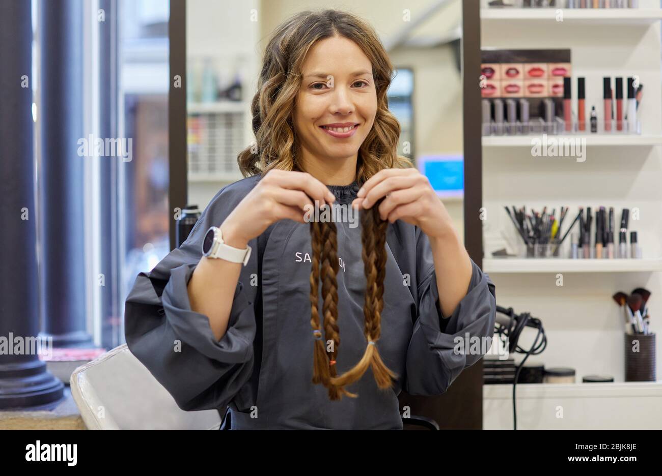 Mujer enseñando trenzas de cabello, Programa de Donación de Cabello, Salón de peluquería y Clínica de Belleza. Foto de stock