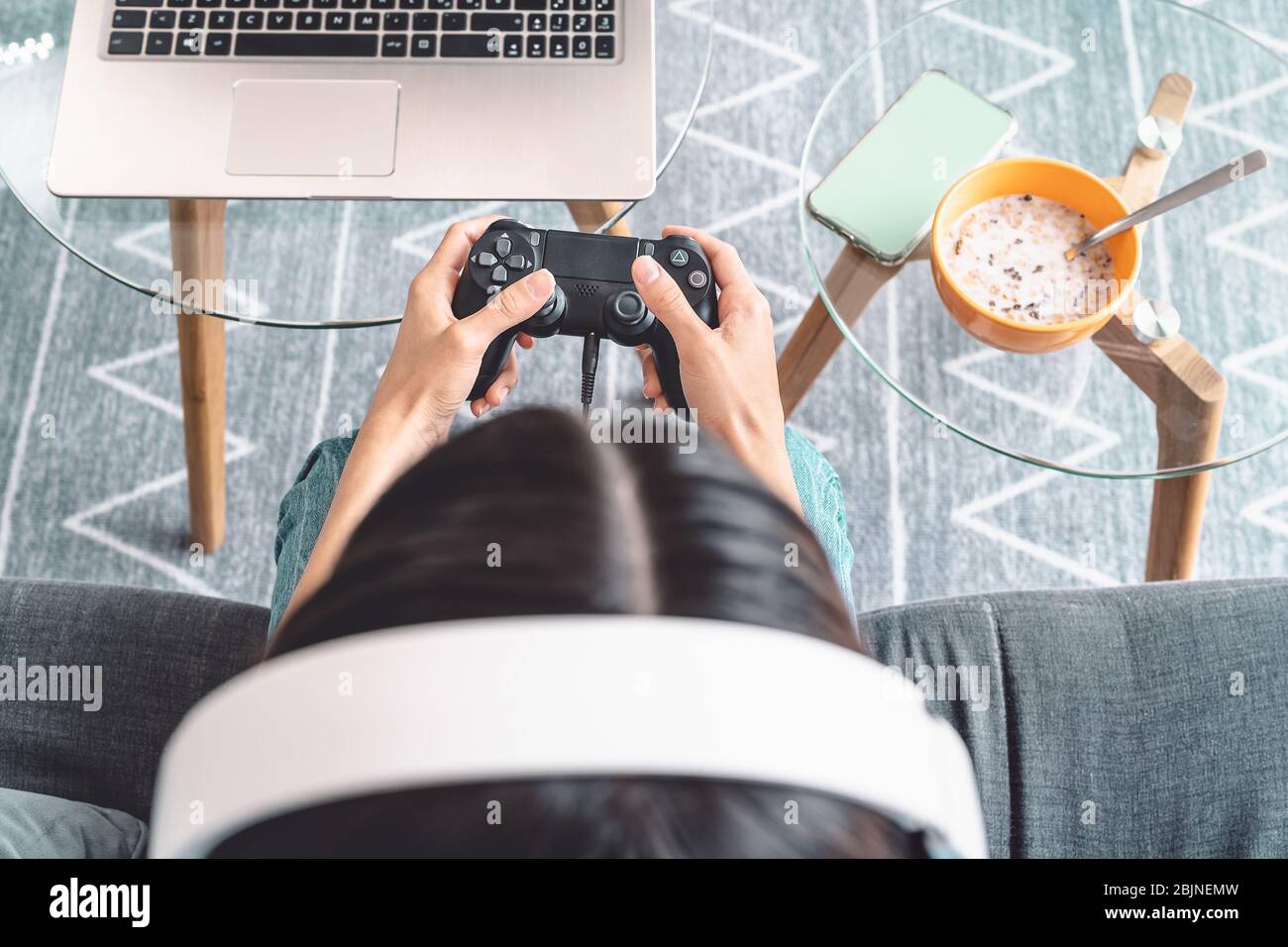 Mujer joven jugando videojuegos en línea - Vista superior jugadora femenina divertirse en la consola de nueva tecnología Foto de stock