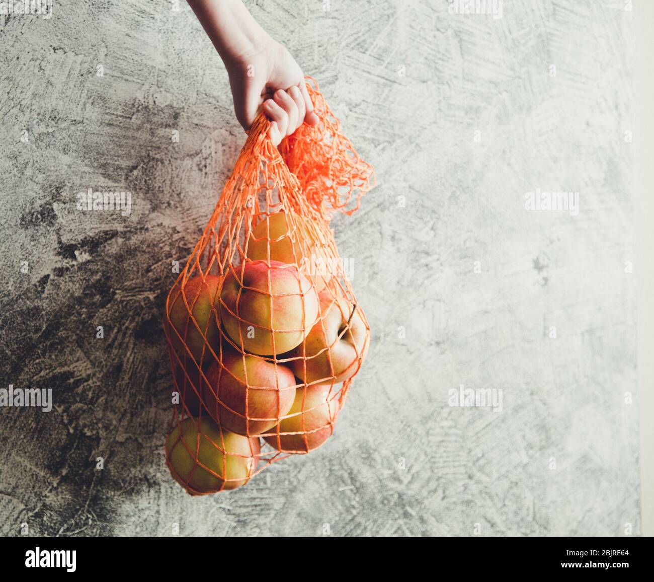 Concepto-ecología, conservación de la naturaleza, sin bolsas de plástico. Bolsa de malla reutilizable con manzanas, espacio de copia/ Foto de stock