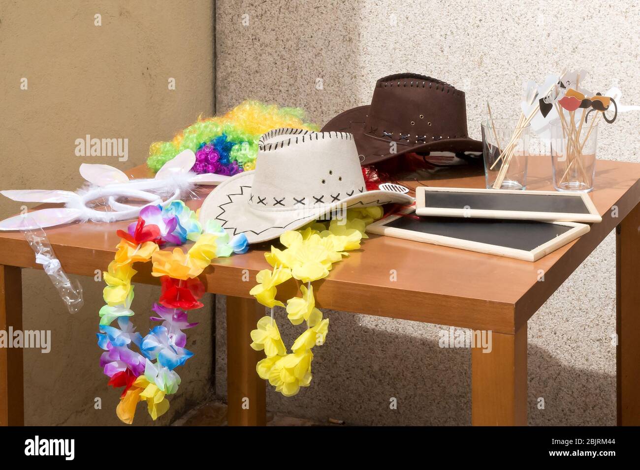 Sombrero blanco de vaquero junto a otros accesorios para una llamada de fotos en una mesa. Foto de stock