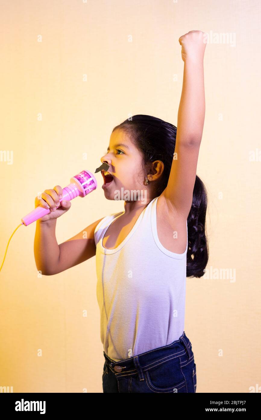 Niña cantando en un micrófono de juguete Fotografía de stock - Alamy