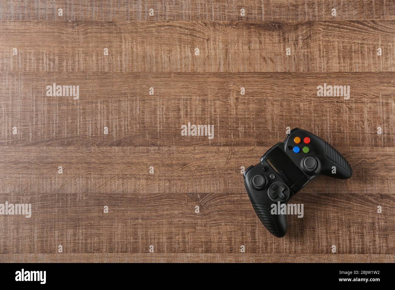 Dispositivo de video juego sobre fondo de madera Foto de stock
