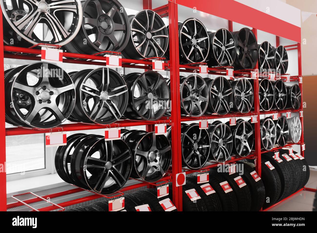 Estantes con llantas de aleación y neumáticos en un moderno centro de  servicio de coches Fotografía de stock - Alamy