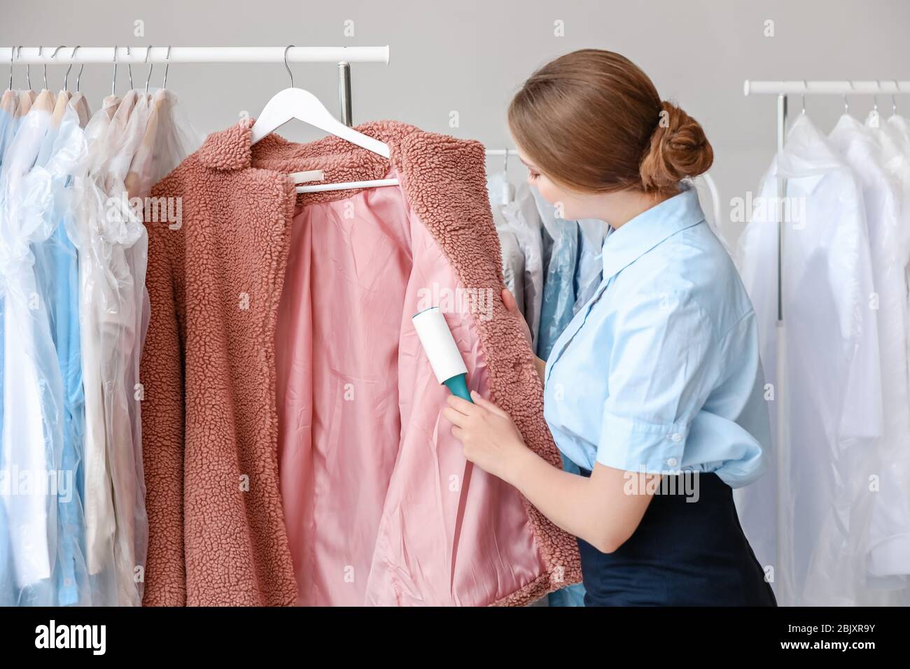 La mujer eliminando la suciedad de la ropa en la tintorería moderna  Fotografía de stock - Alamy