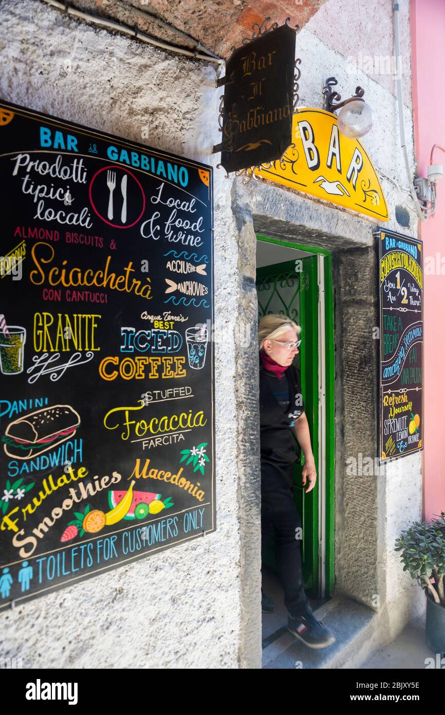 La mujer emerge de un snack bar en el punto medio de 2 horas de caminata entre los pueblos de Corneglia y Vernazza en el famoso sendero que conecta 5 seasi UNESCO Foto de stock