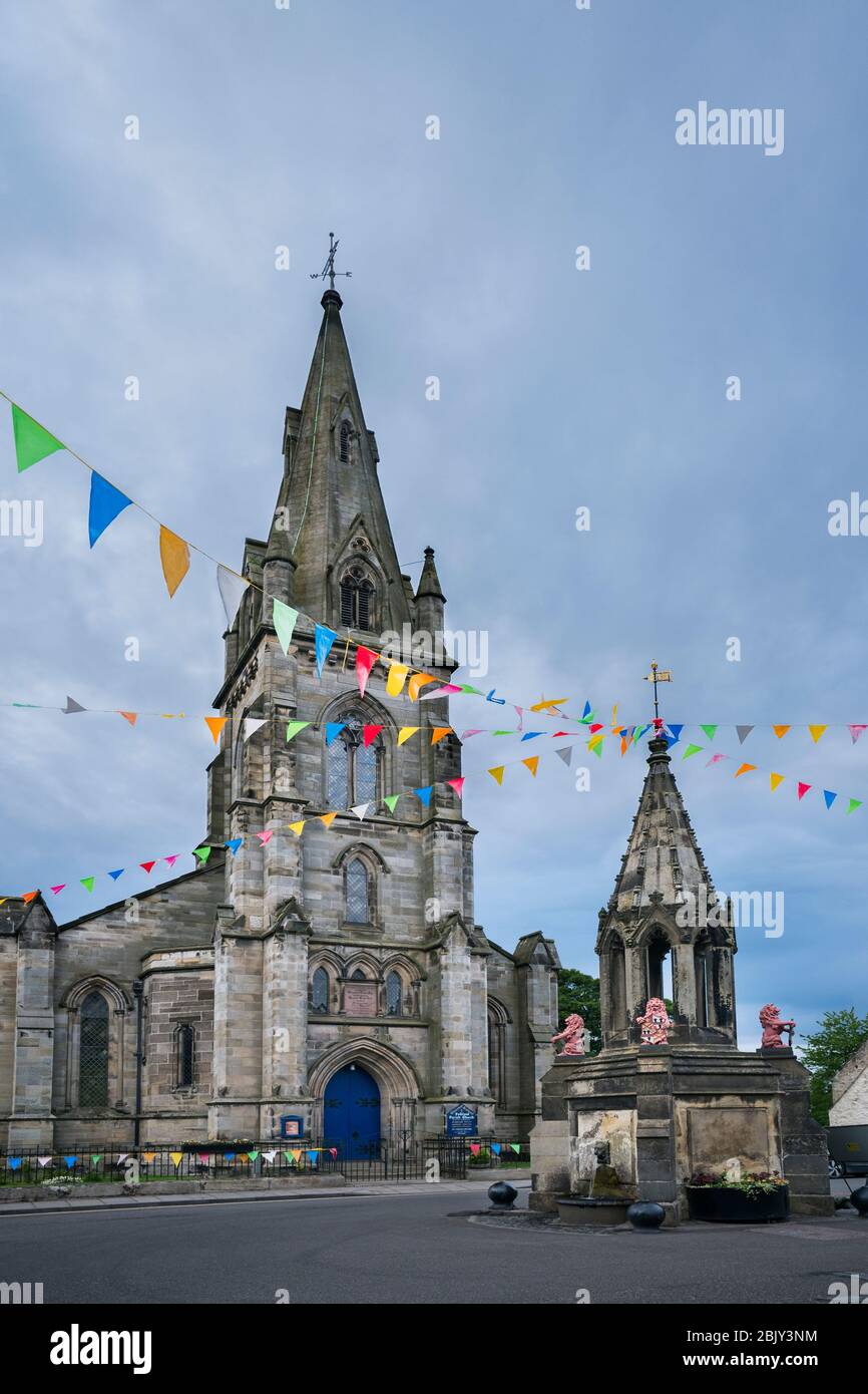 Iglesia Parroquial de Escocia, una estructura de piedra alta frente a la Fuente Bruce en la plaza central del mercado de la pequeña villa medieval, Malvinas, Fife, SCO Foto de stock