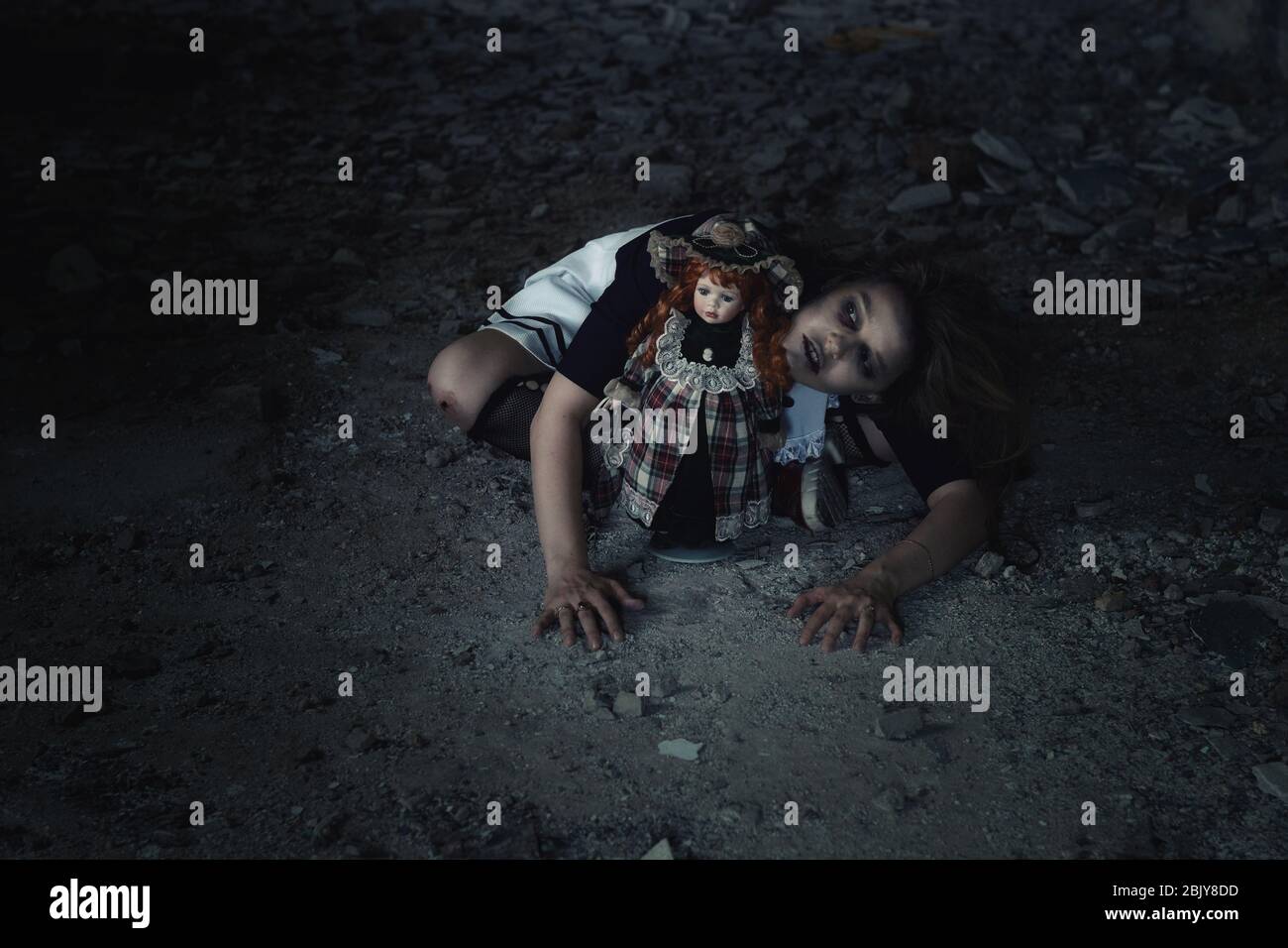 niña asustadiza con una muñeca en una casa abandonada Foto de stock