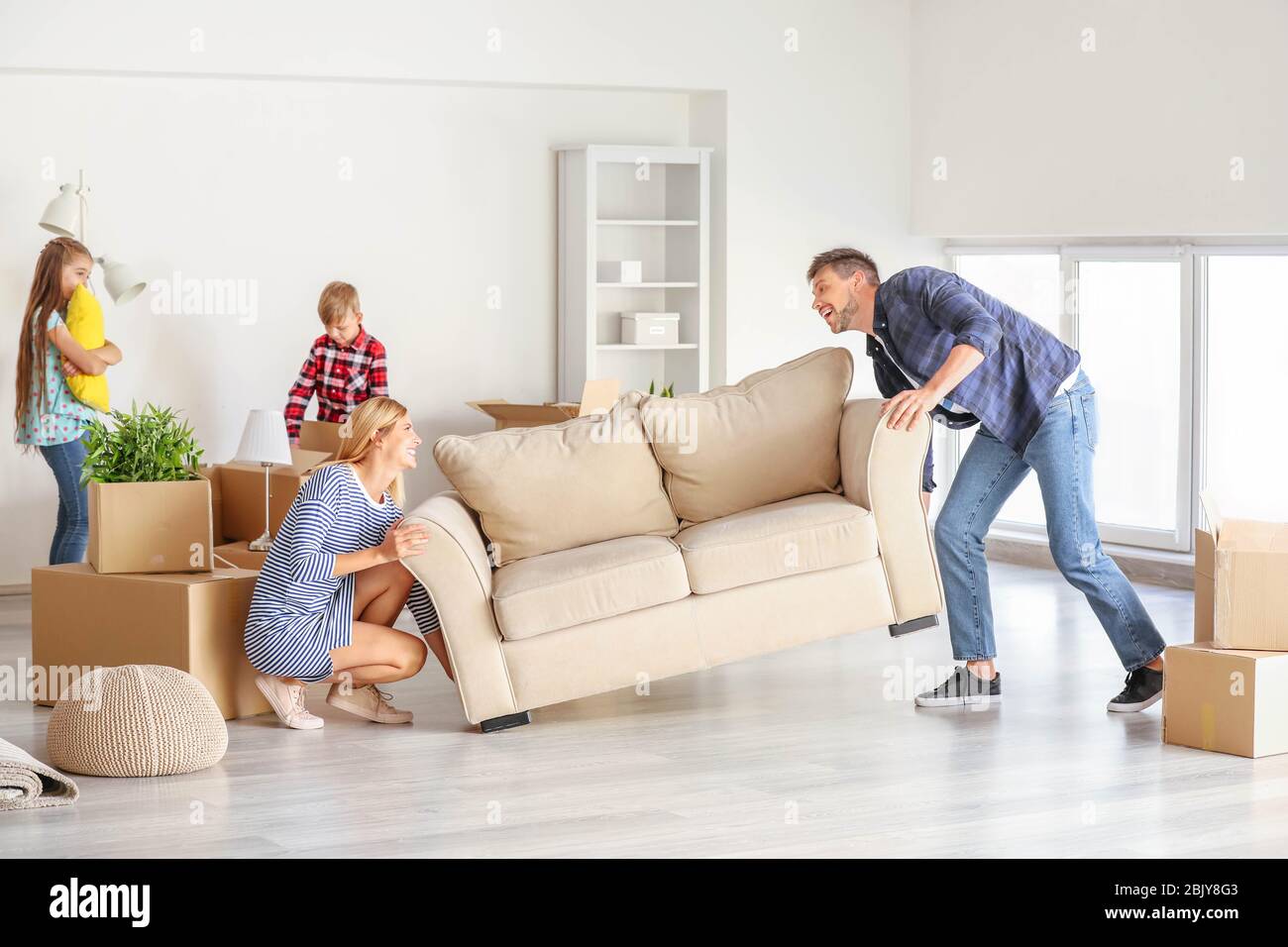 Mover los muebles de familia feliz en su nueva casa Fotografía de stock -  Alamy