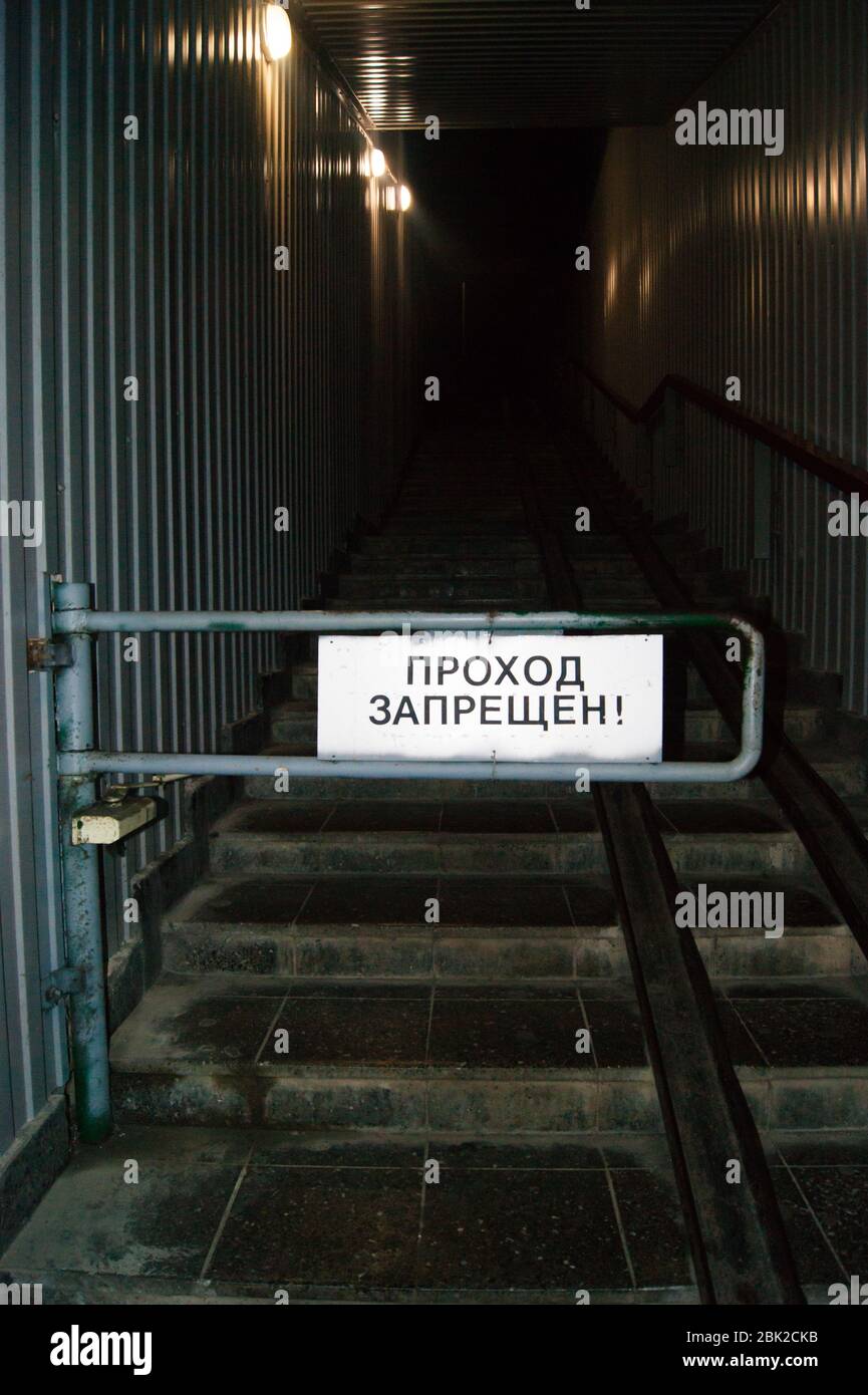 Ruta cerrada. Schlagbaum en el paso subterráneo, en la inscripción del signo, traducción al ruso - el pasaje está prohibido. Escalera arriba, mazmorra, de ninguna manera Foto de stock