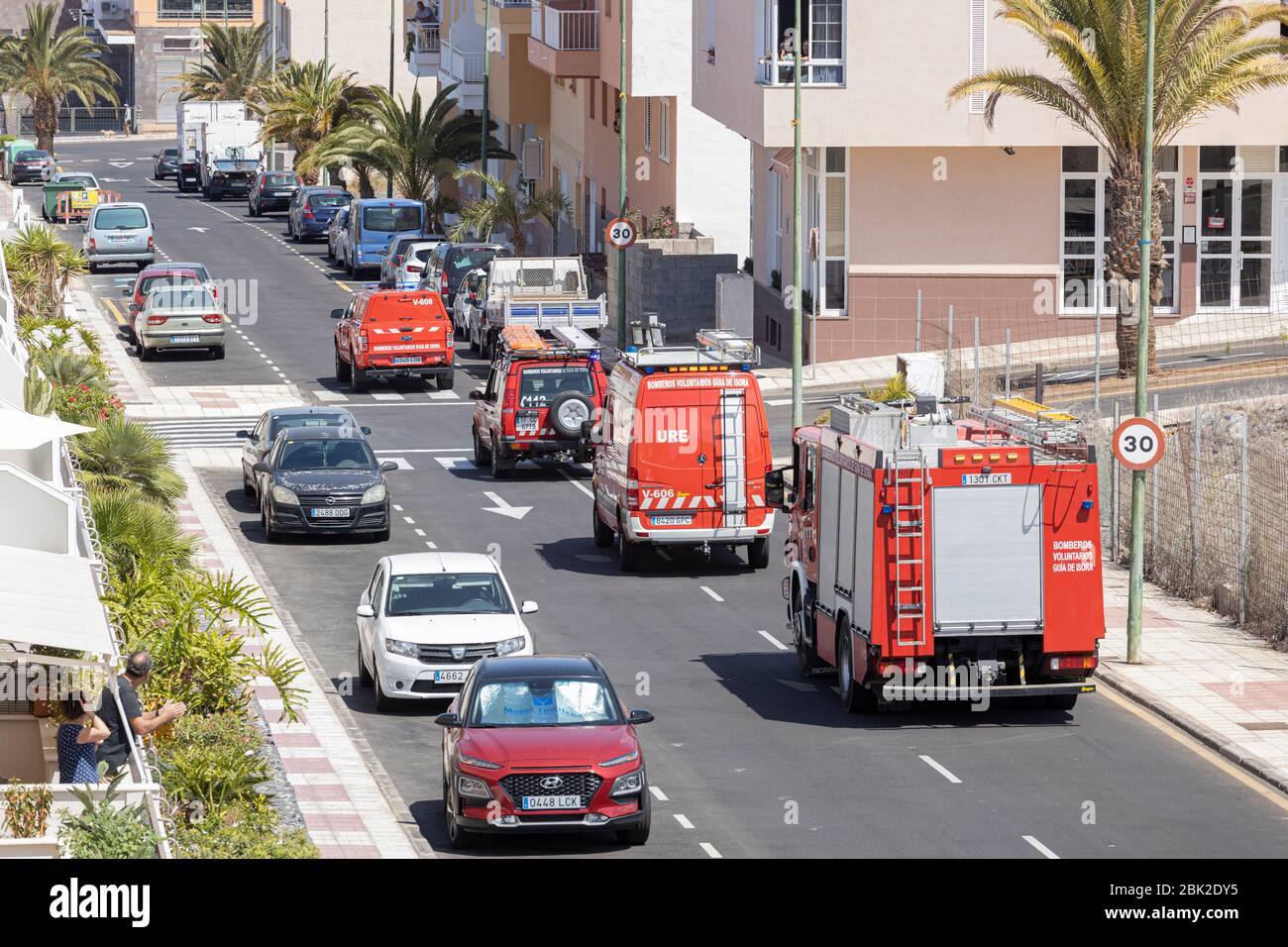 Bomberos voluntarios en coche a través del pueblo con sirena y luces intermitentes, covid 19 estado de emergencia, Playa San Juan, Tenerife, Islas Canarias, Foto de stock