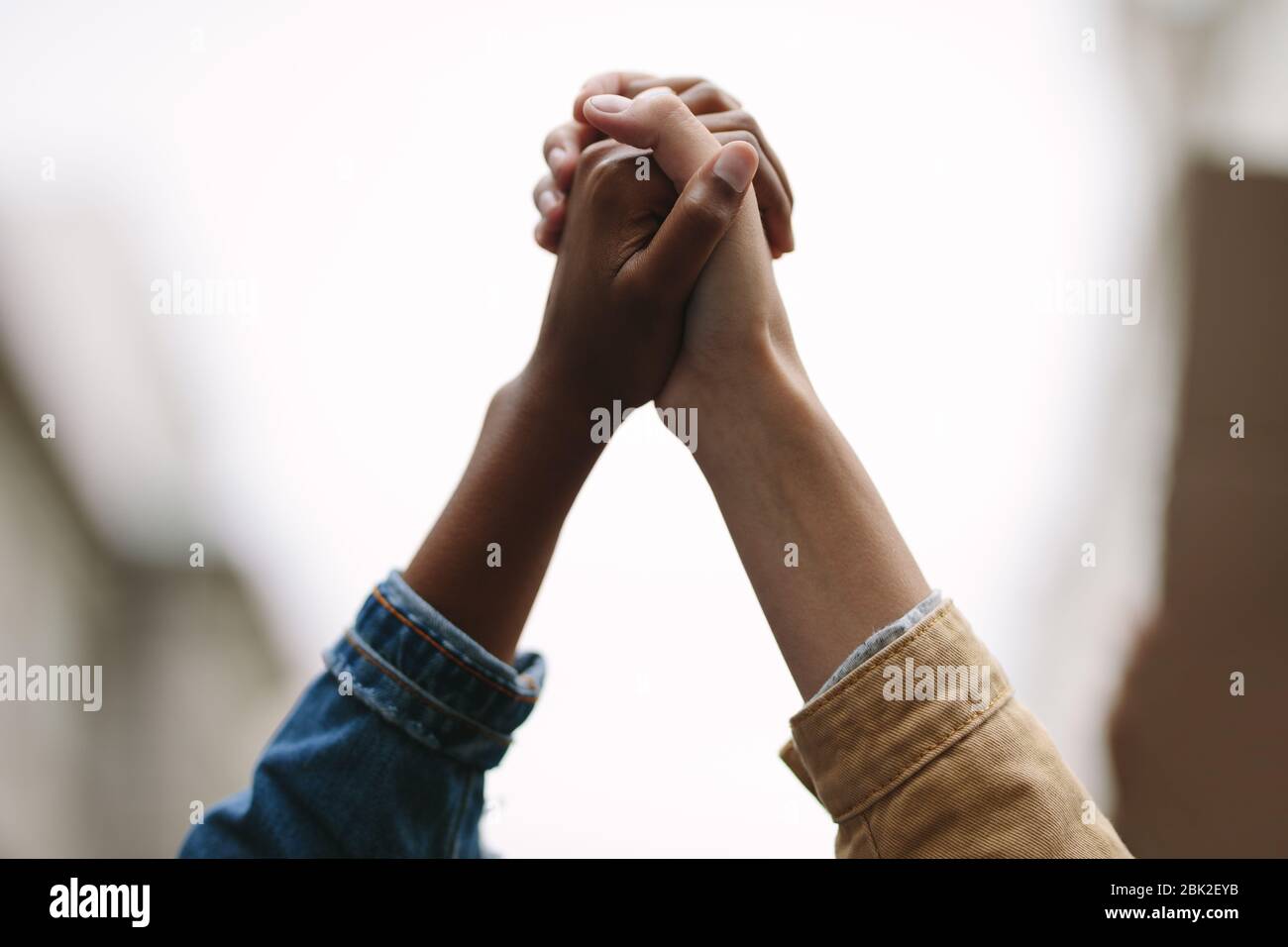 Símbolo de unidad. Dos mujeres activistas se aferran. Manifestantes protestando juntos con las manos. Foto de stock