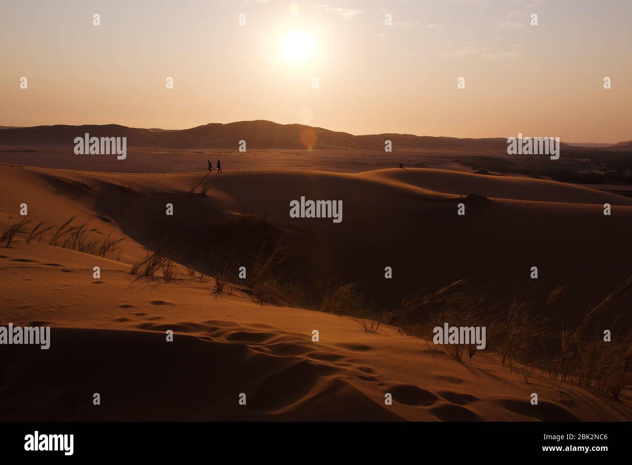 Puesta de sol en el desierto, dos figuras siluetas Foto de stock