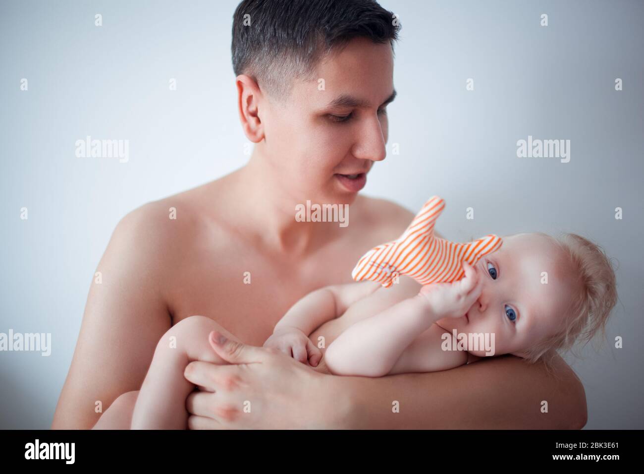Padre con su bebé caricias y le beso en la mejilla. La paternidad, el amor. Foto de stock