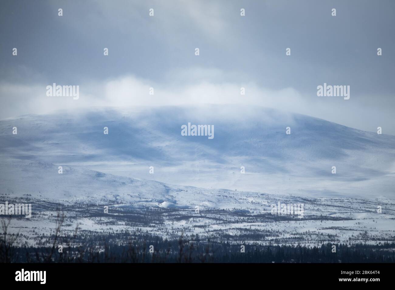 Paisaje invernal con montañas nevadas y nubladas. Foto de stock