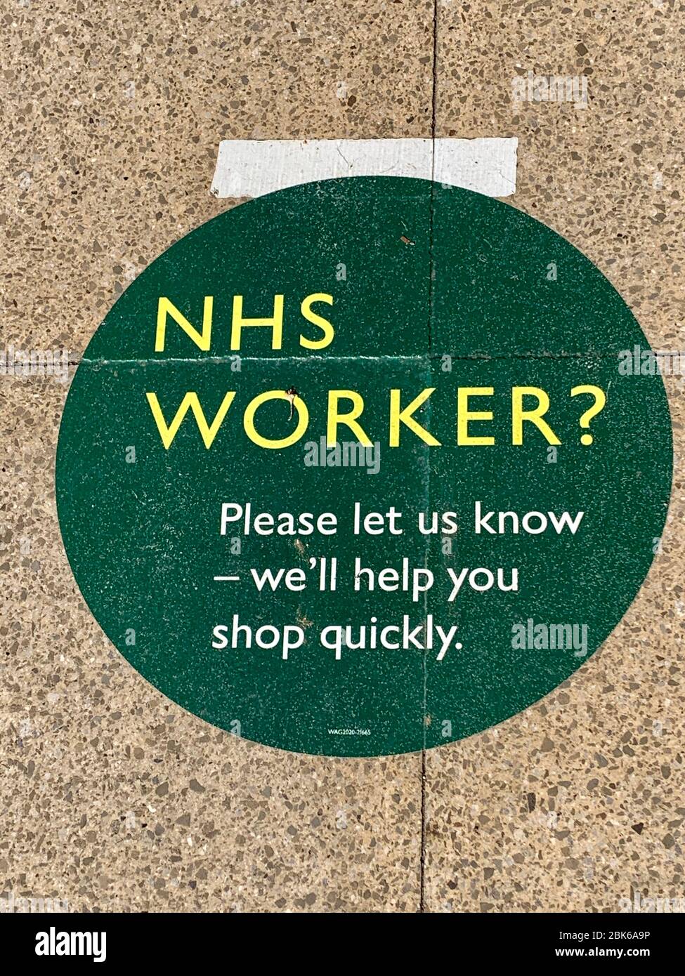 NHS trabajador (trabajador clave) tienda rápidamente firmar en el piso fuera de Waitrose Supermarket en respuesta a covid-19 coronavirus pandemia Foto de stock