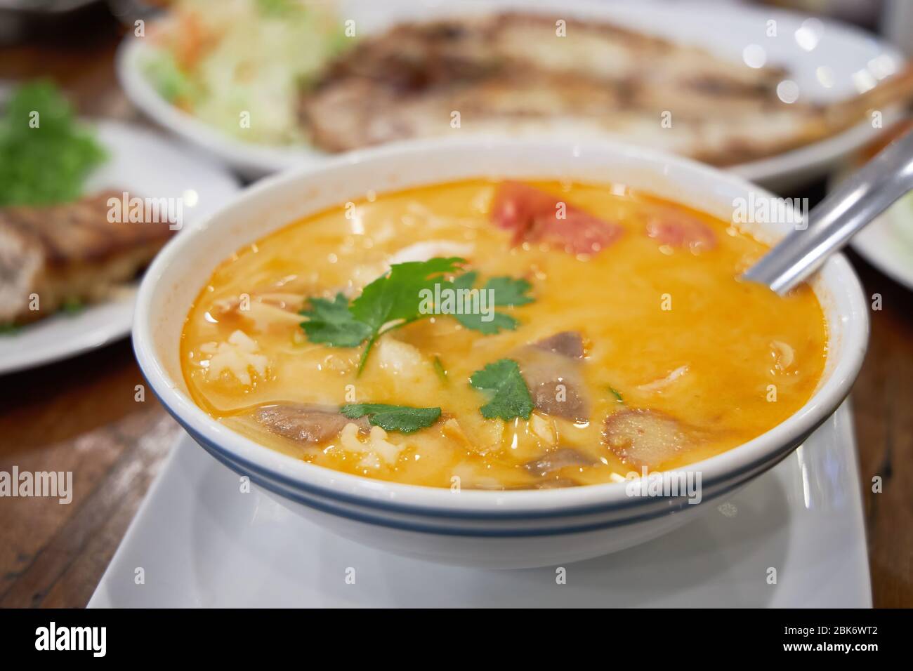 Plato grande de deliciosa sopa tailandesa picante Tom Yam como plato principal para el almuerzo. Foto de stock