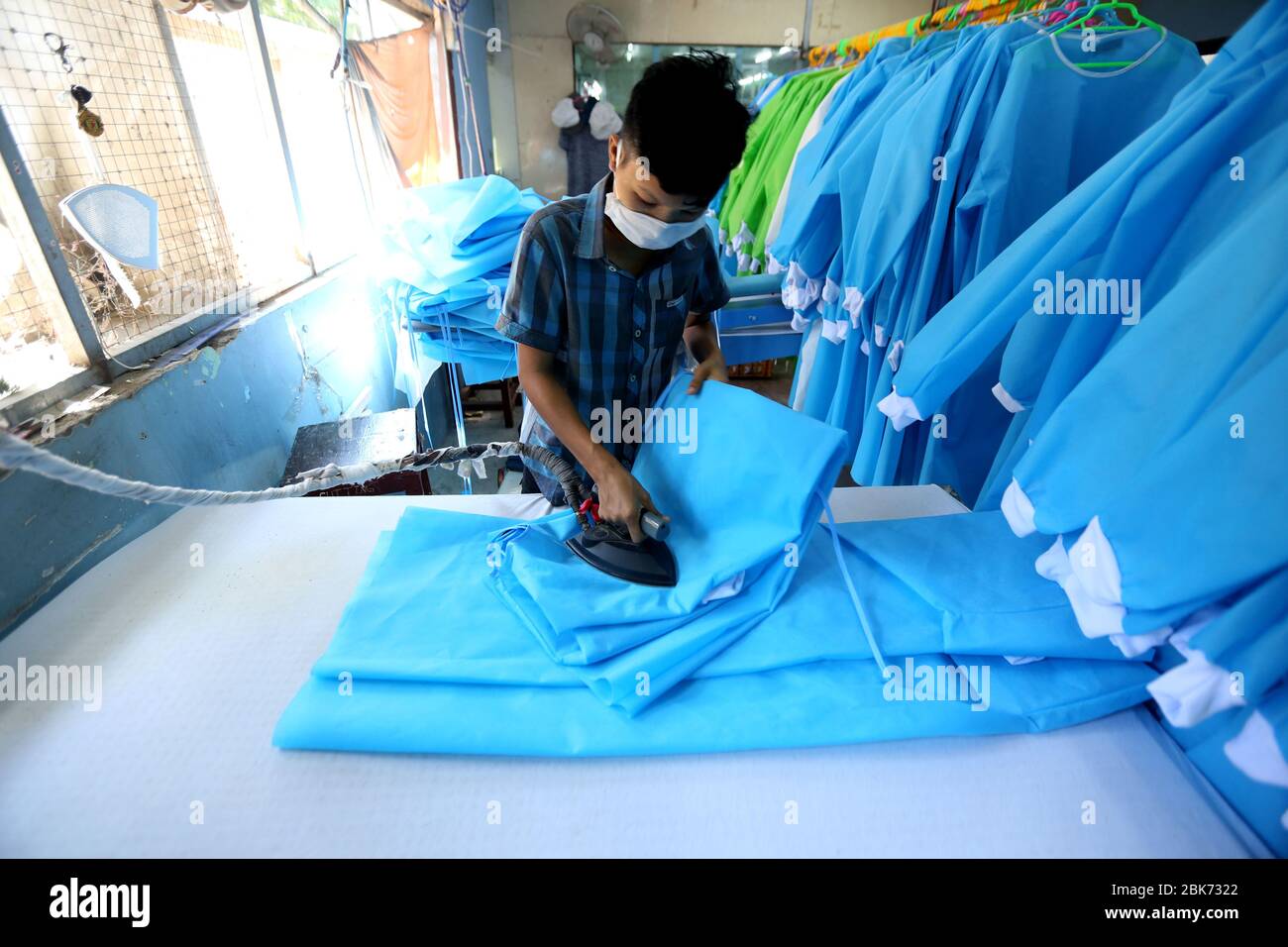 Yangon, Myanmar. 2 de mayo de 2020. Un trabajador hace vestidos quirúrgicos  en una fábrica de ropa en Yangon, Myanmar, el 2 de mayo de 2020. Una  fábrica de prendas de vestir