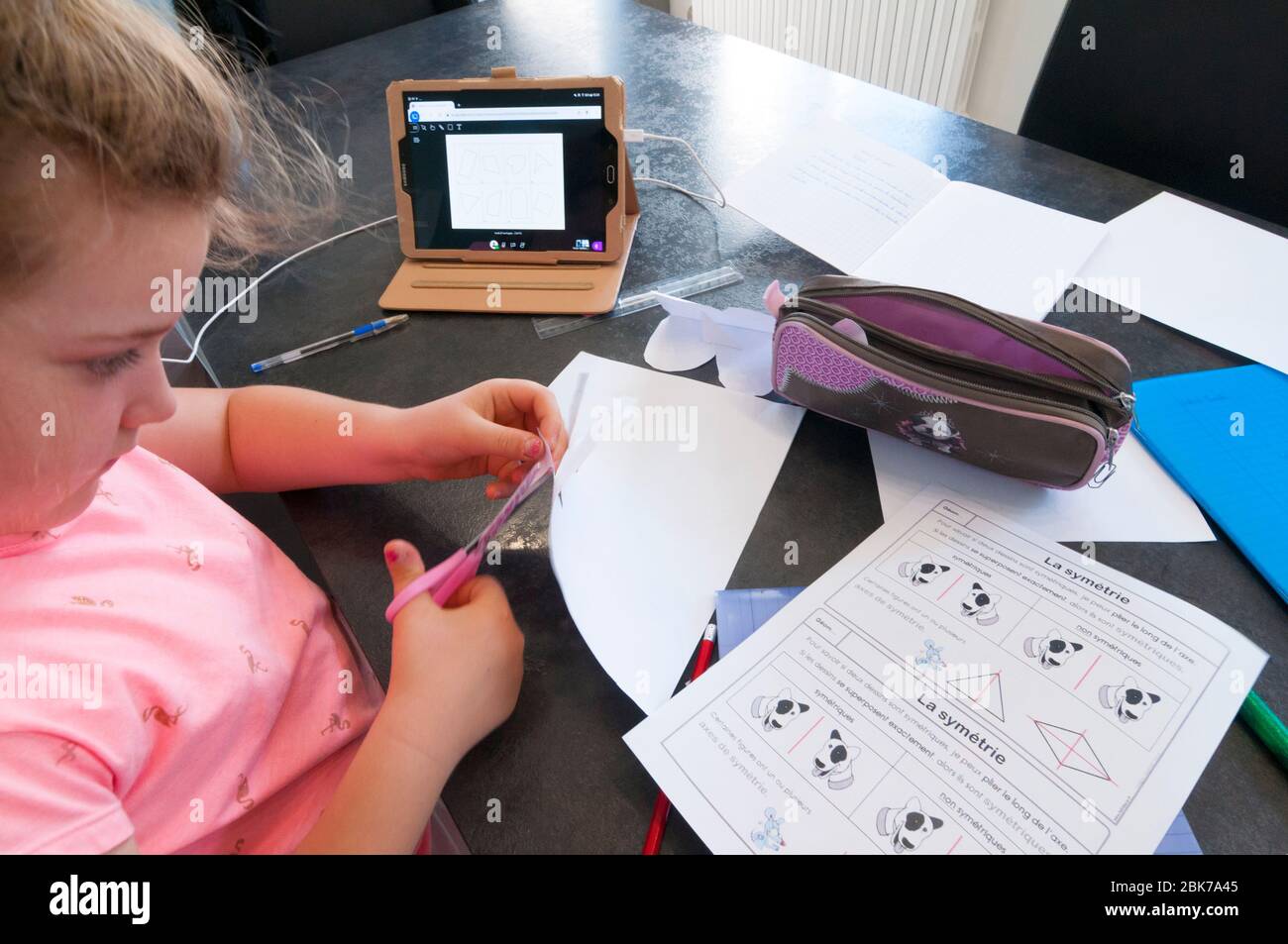 Francia, Loiret (45), Covid-19 cierre francés el 04/27/2020, niña de 7 años en CE1 durante la clase virtual de la escuela en casa utilizando la tableta remota Foto de stock